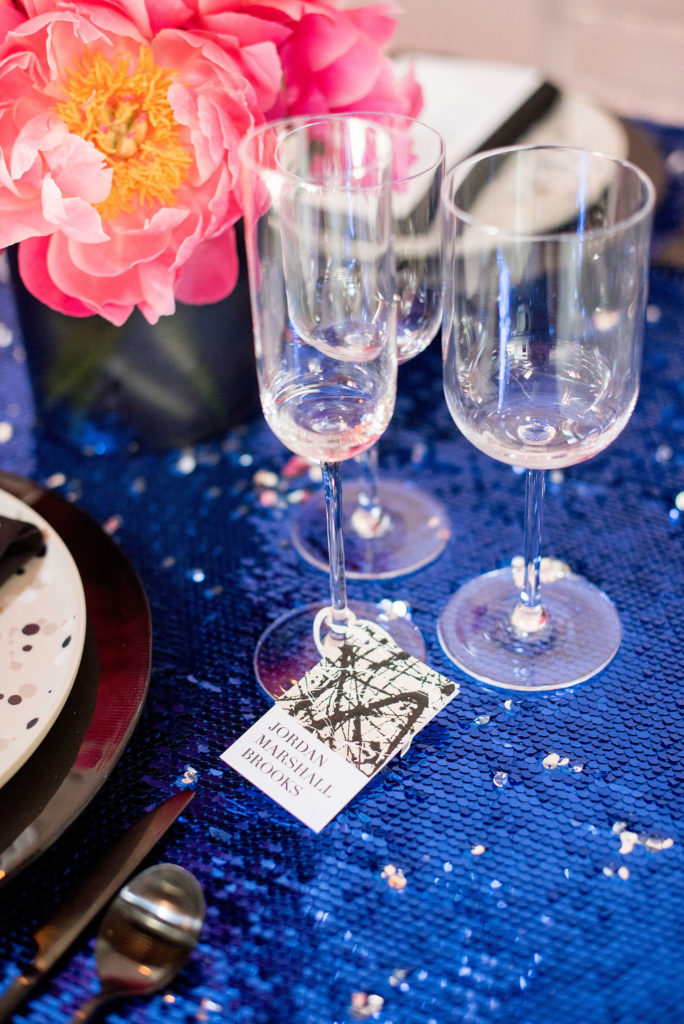 Mikkel Paige Photography photo of Dobbin St Brooklyn wedding. Planning and coordination by Color Pop Events. Unique canvas and cardstock place cards on a table with blue sequin linen.