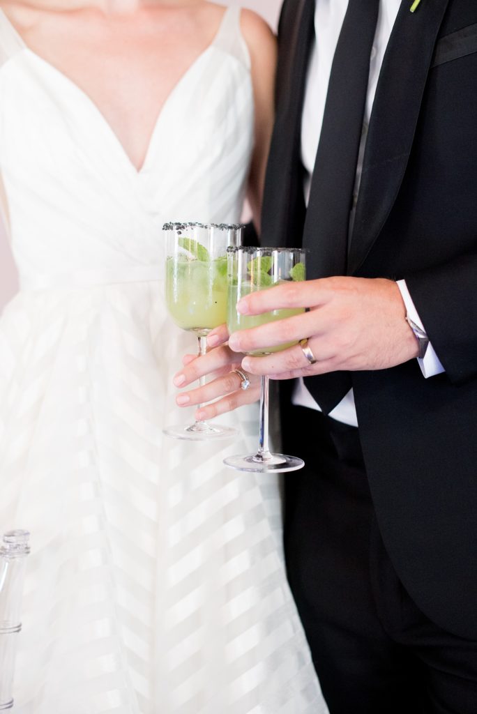 Mikkel Paige Photography photo of Dobbin St Brooklyn wedding. Planning and coordination by Color Pop Events. Reception toast cheers with the bride and groom drinking a custom cucumber cocktail.