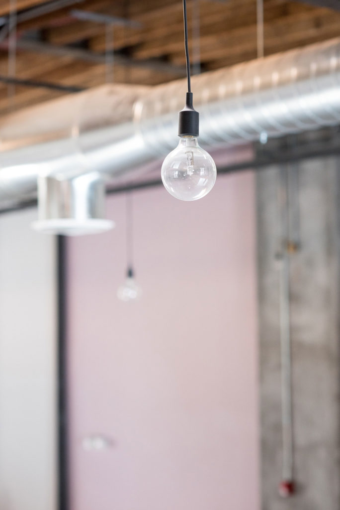 Mikkel Paige Photography photo of Dobbin St Brooklyn wedding. Planning and coordination by Color Pop Events. Exposed bulbs lighting and mauve accent wall color.