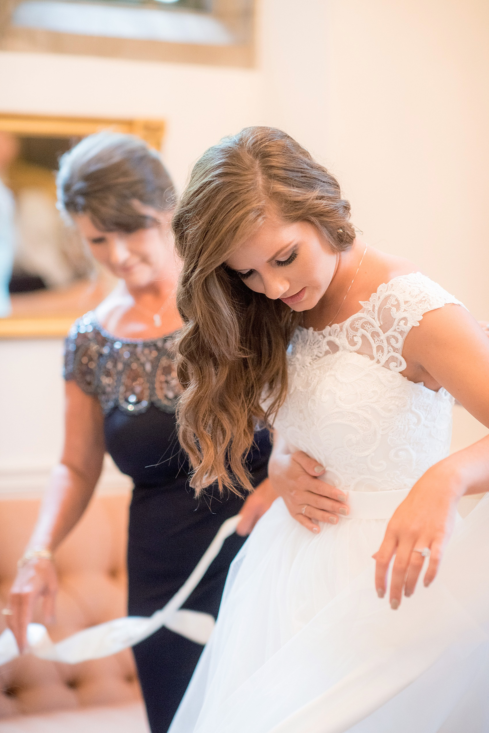 Mikkel Paige Photography photo of a Duke Chapel wedding in Durham, North Carolina with the bride getting dressed in her wedding gown with her mother.