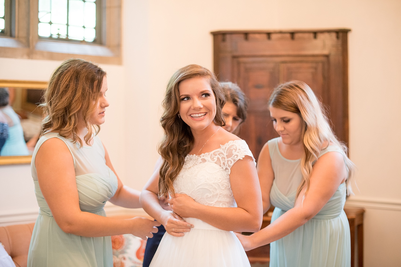 Mikkel Paige Photography photo of a Duke Chapel wedding in Durham, North Carolina with the bride getting dressed in her wedding gown.