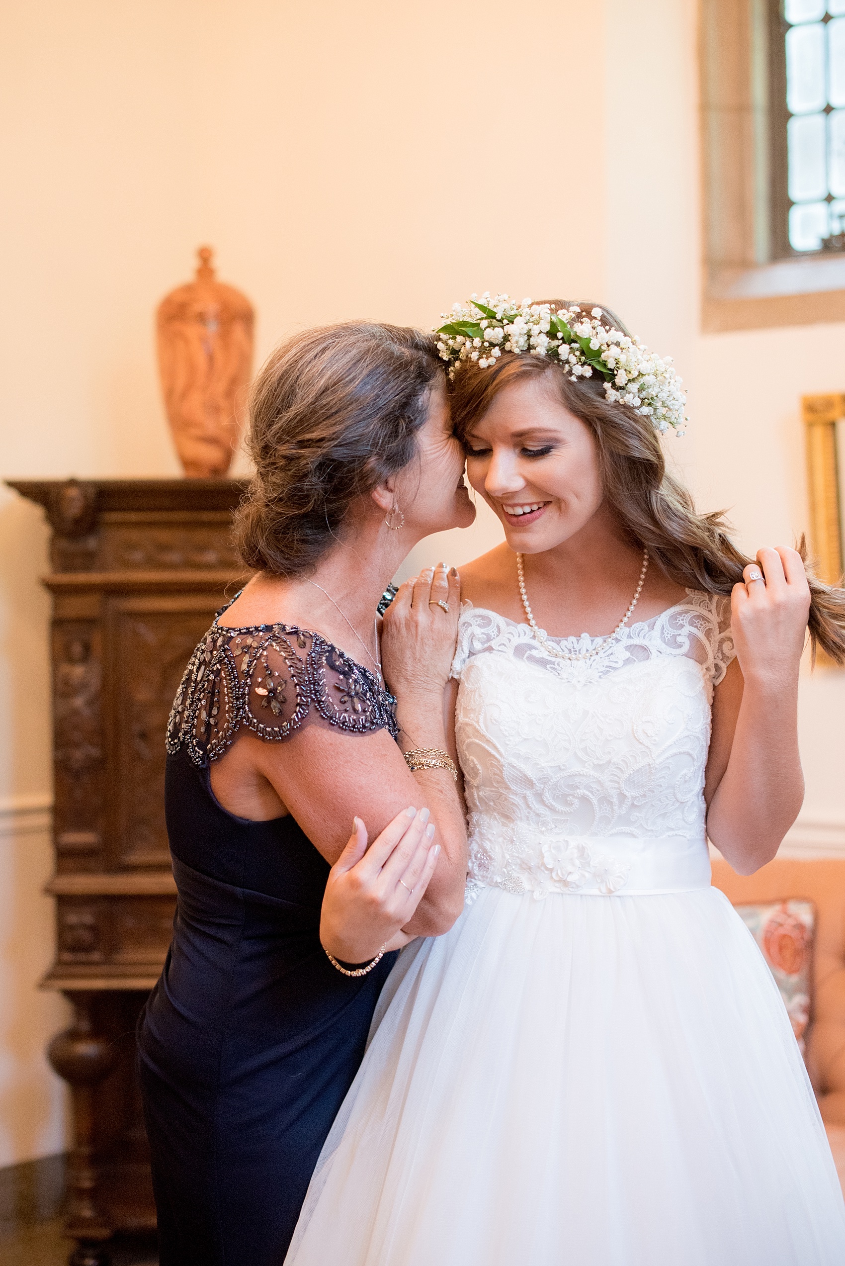 Mikkel Paige Photography photo of a Duke Chapel wedding in Durham, North Carolina with the bride getting dressed in her wedding gown with her mother.