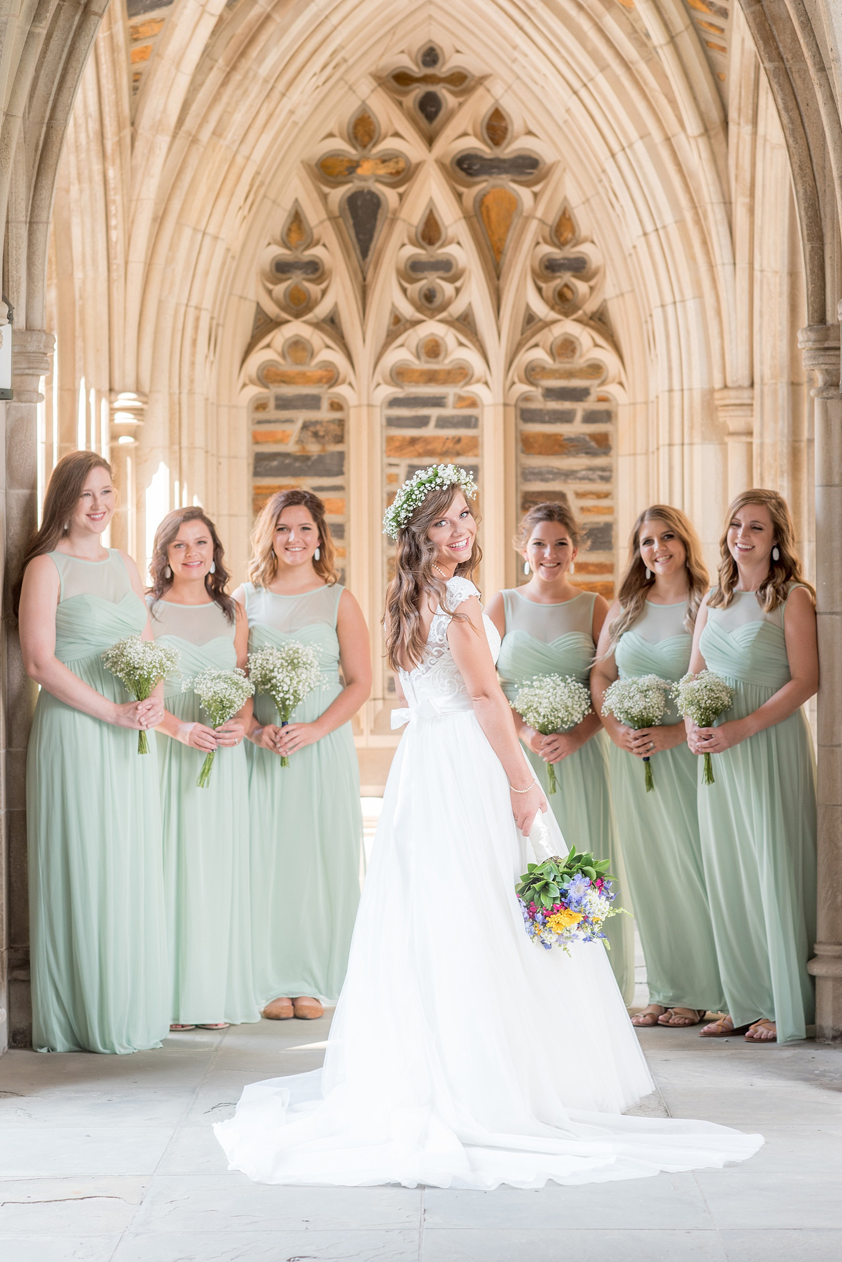 Mikkel Paige Photography photo of a Duke Chapel wedding in Durham, North Carolina. The bride in a lace cap sleeve gown and her bridesmaids mint green gowns under the gothic arches of the iconic church.