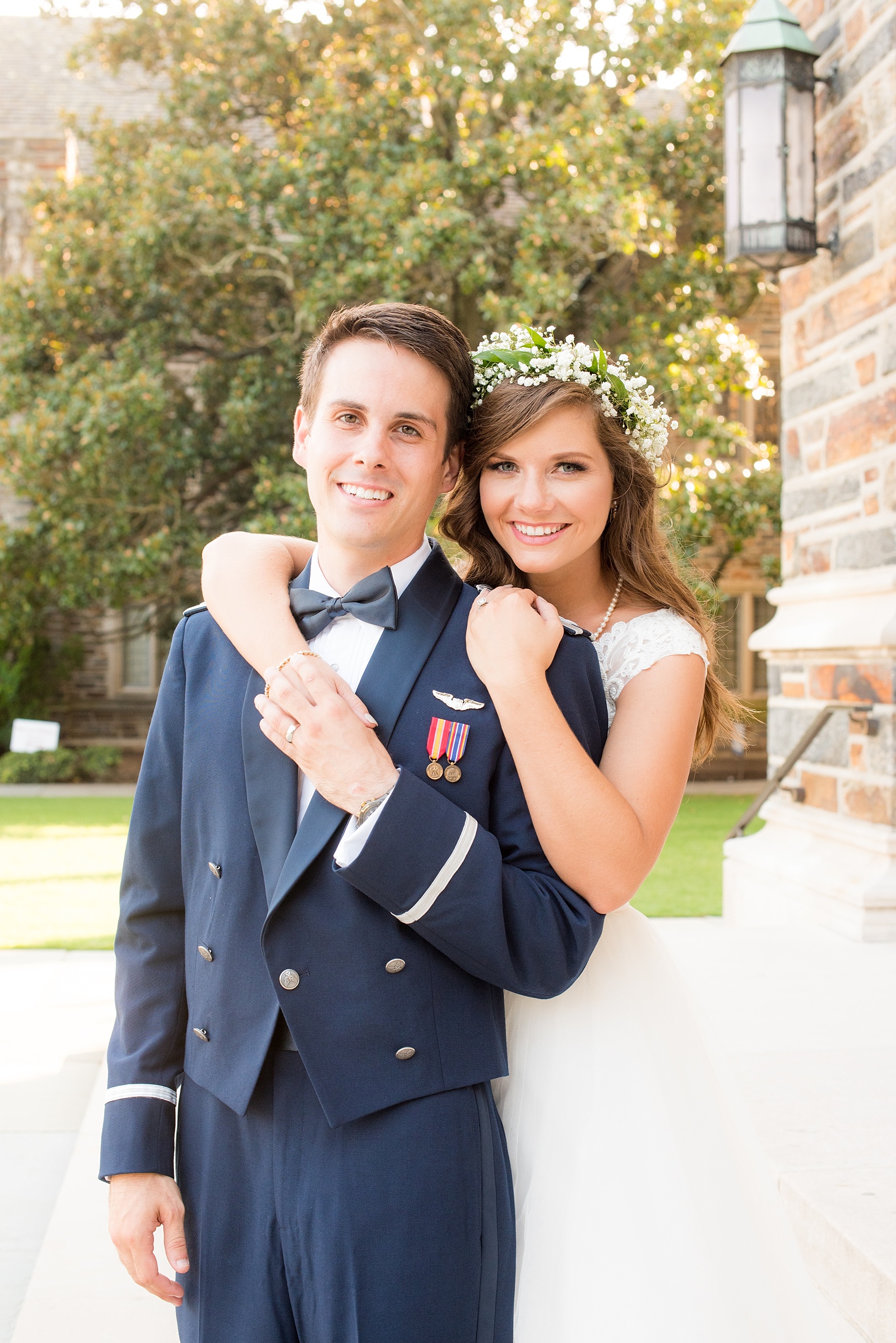 Mikkel Paige Photography photo of a Duke Chapel wedding in Durham, North Carolina. The bride and groom kiss in her lace cap gown and his navy blue Air Force uniform.