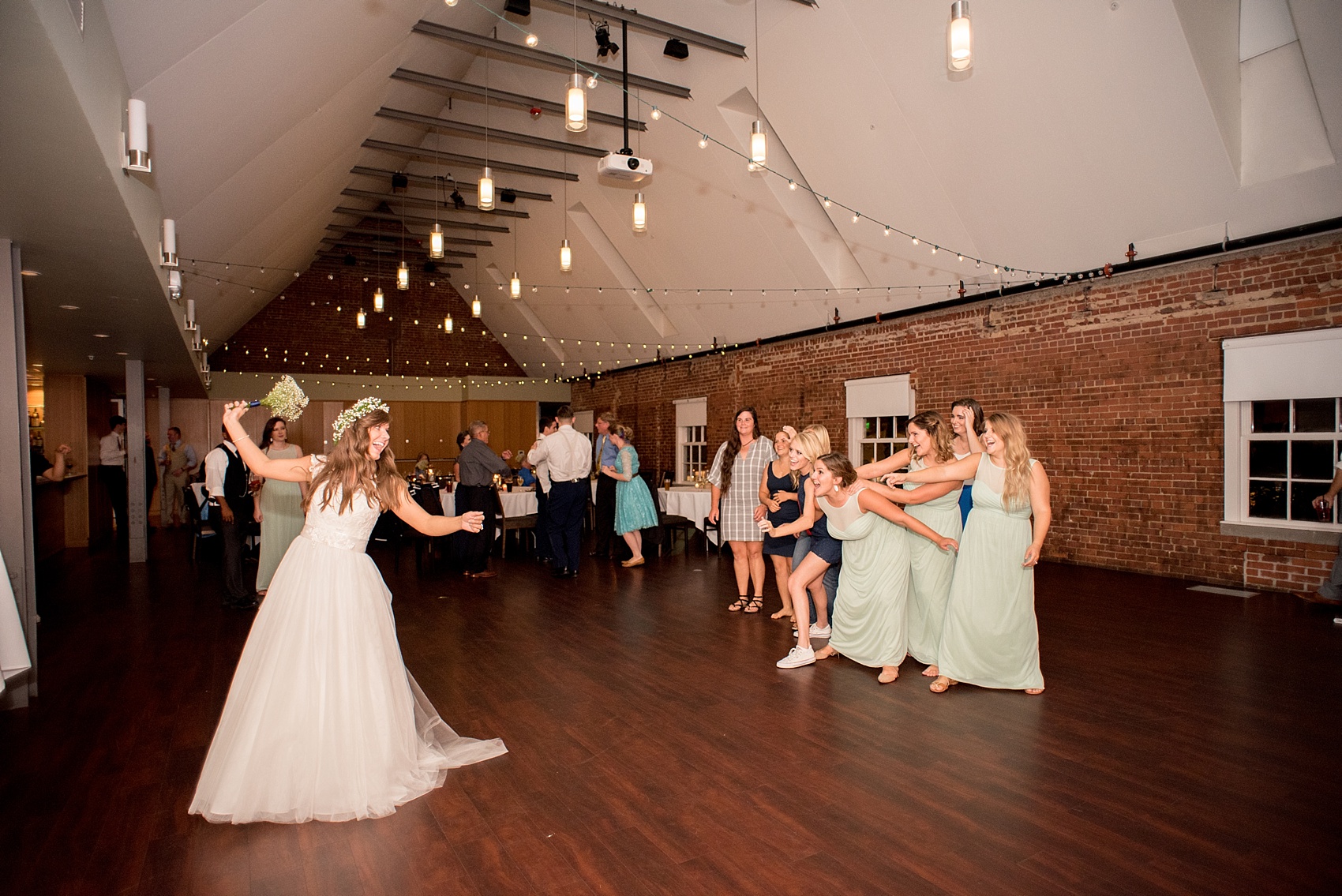 Mikkel Paige Photography photo of a Top of the Hill reception in Chapel Hill, NC with the bride doing a bouquet toss.