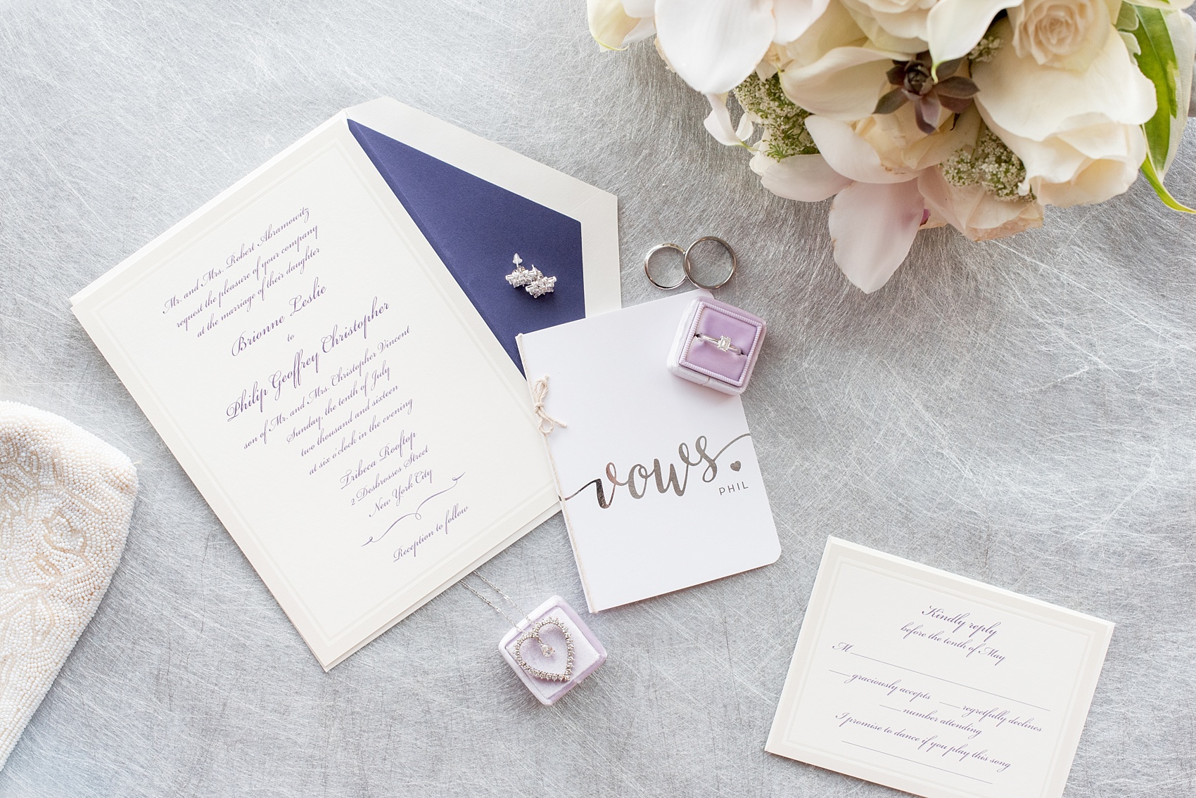 Mikkel Paige Photography photos of a NYC wedding at Tribeca Rooftop. A lay down image of details of the day including a vow book, invitation and purple Mrs. Box.