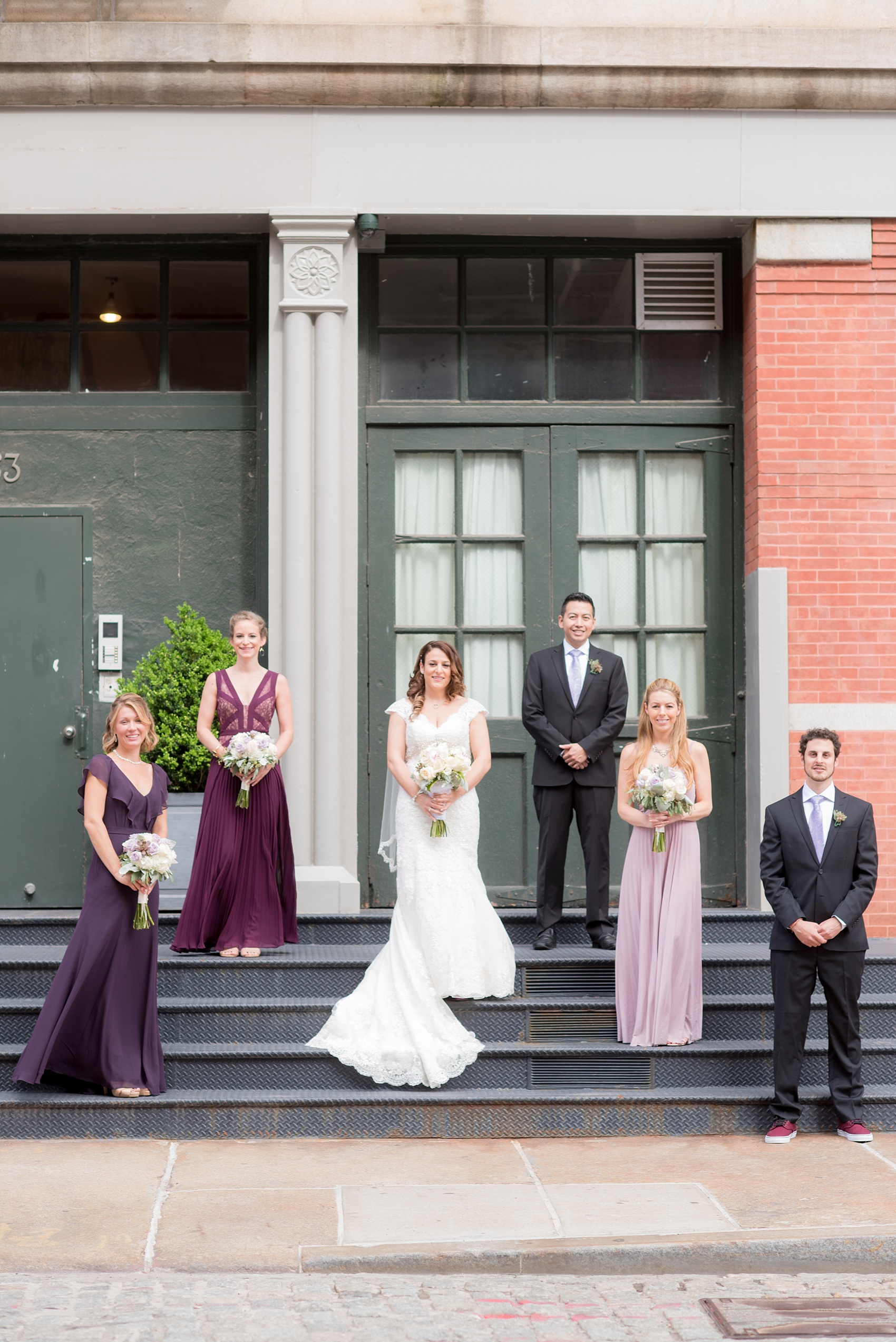 Mikkel Paige Photography photos of a NYC wedding at Tribeca Rooftop. An urban image of the wedding party in shades of mismatched purple dresses.