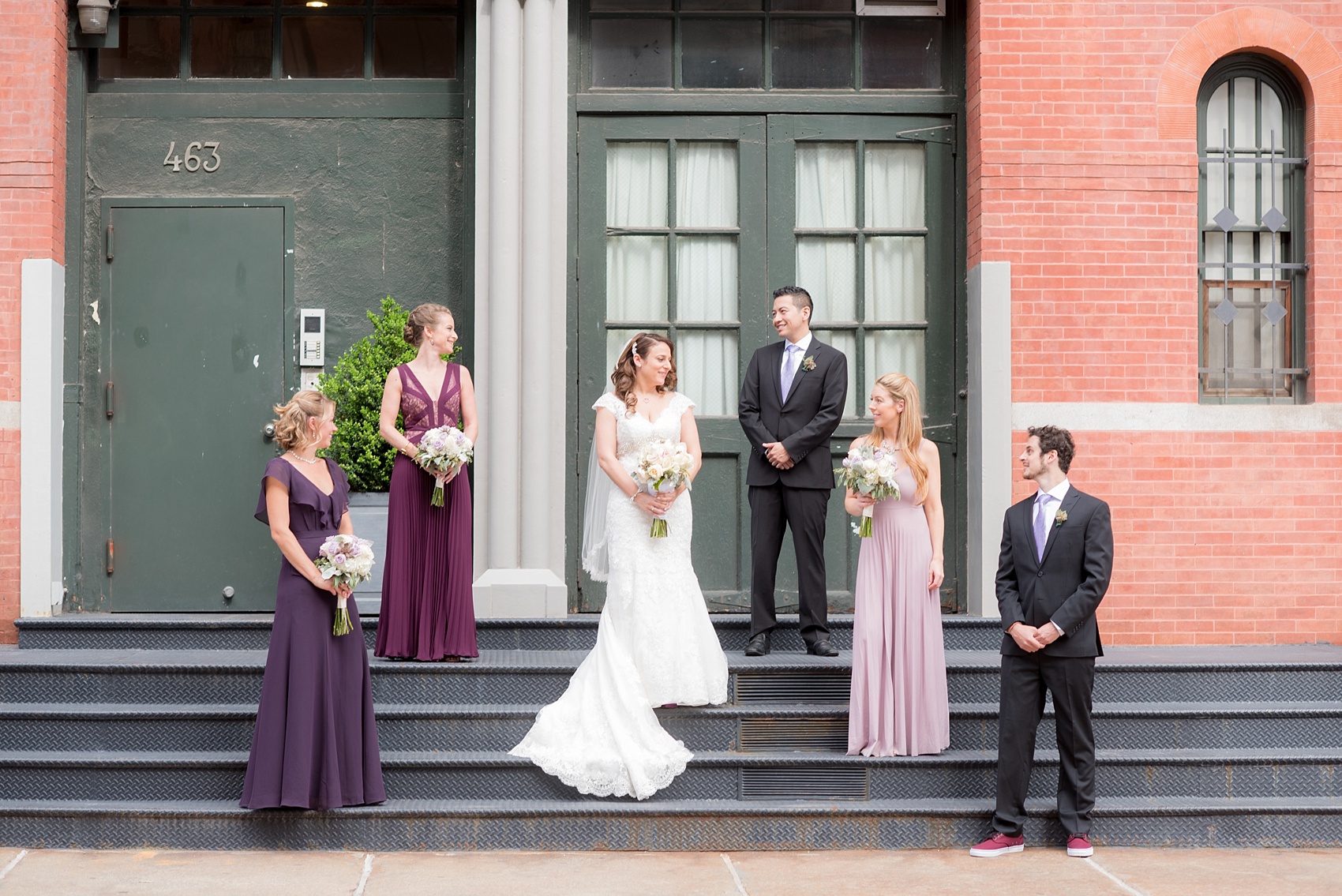 Mikkel Paige Photography photos of a NYC wedding at Tribeca Rooftop. An urban image of the wedding party in shades of mismatched purple dresses.