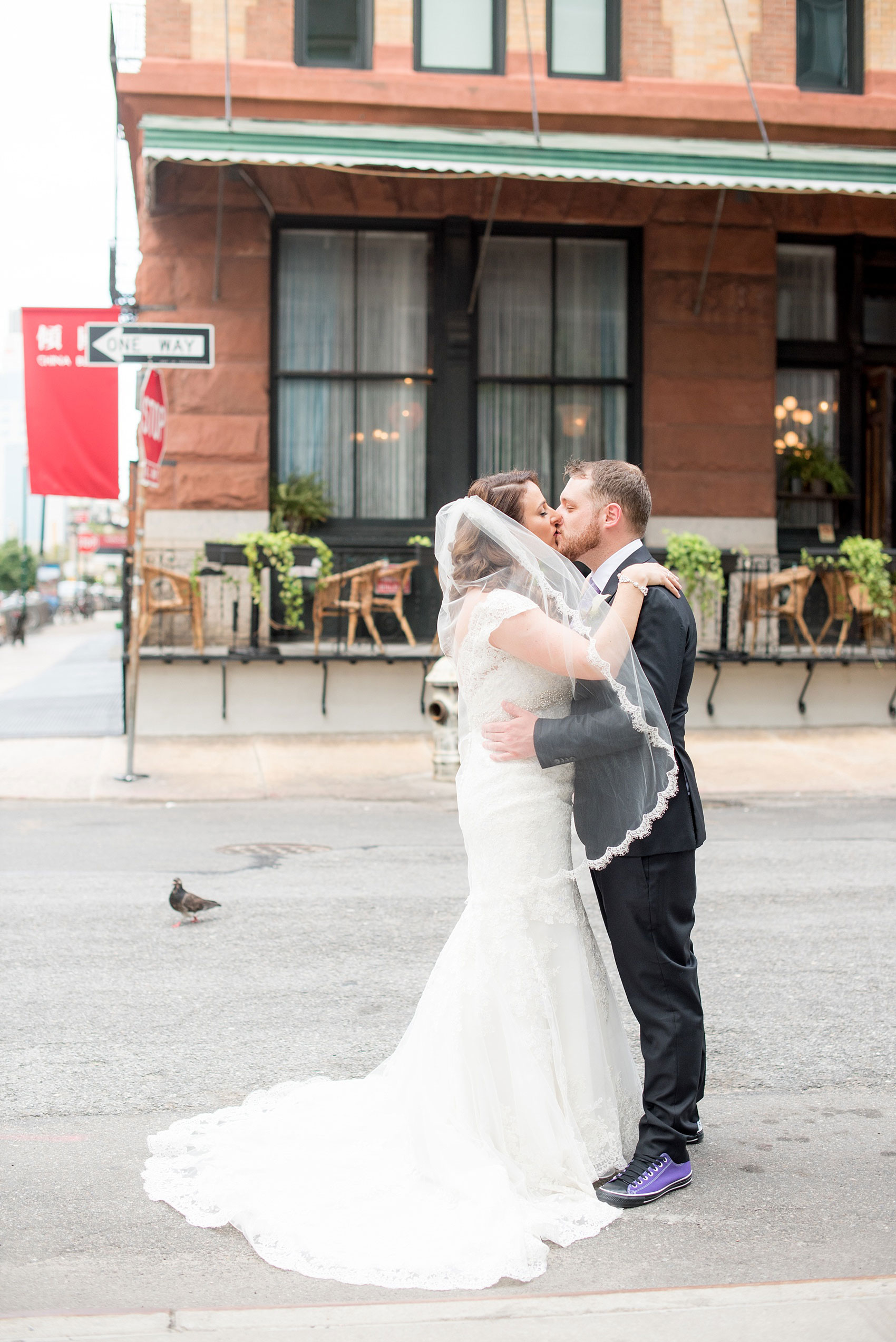 Mikkel Paige Photography photos of a NYC wedding at Tribeca Rooftop. An urban street image of the bride and groom kissing.
