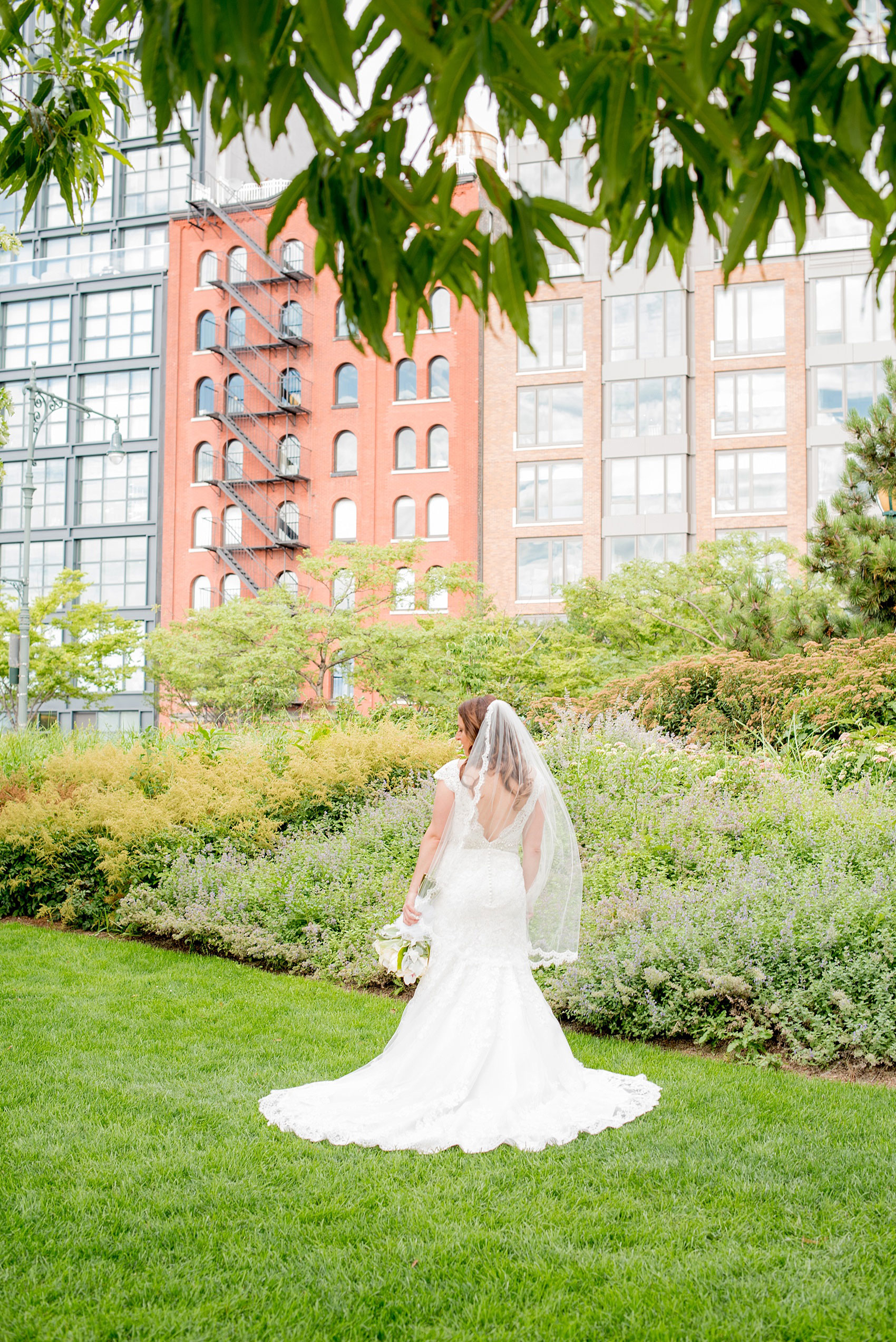 Mikkel Paige Photography photos of a NYC wedding at Tribeca Rooftop. An image of the bride in her Anita Graham lace gown at Hudson River Park.