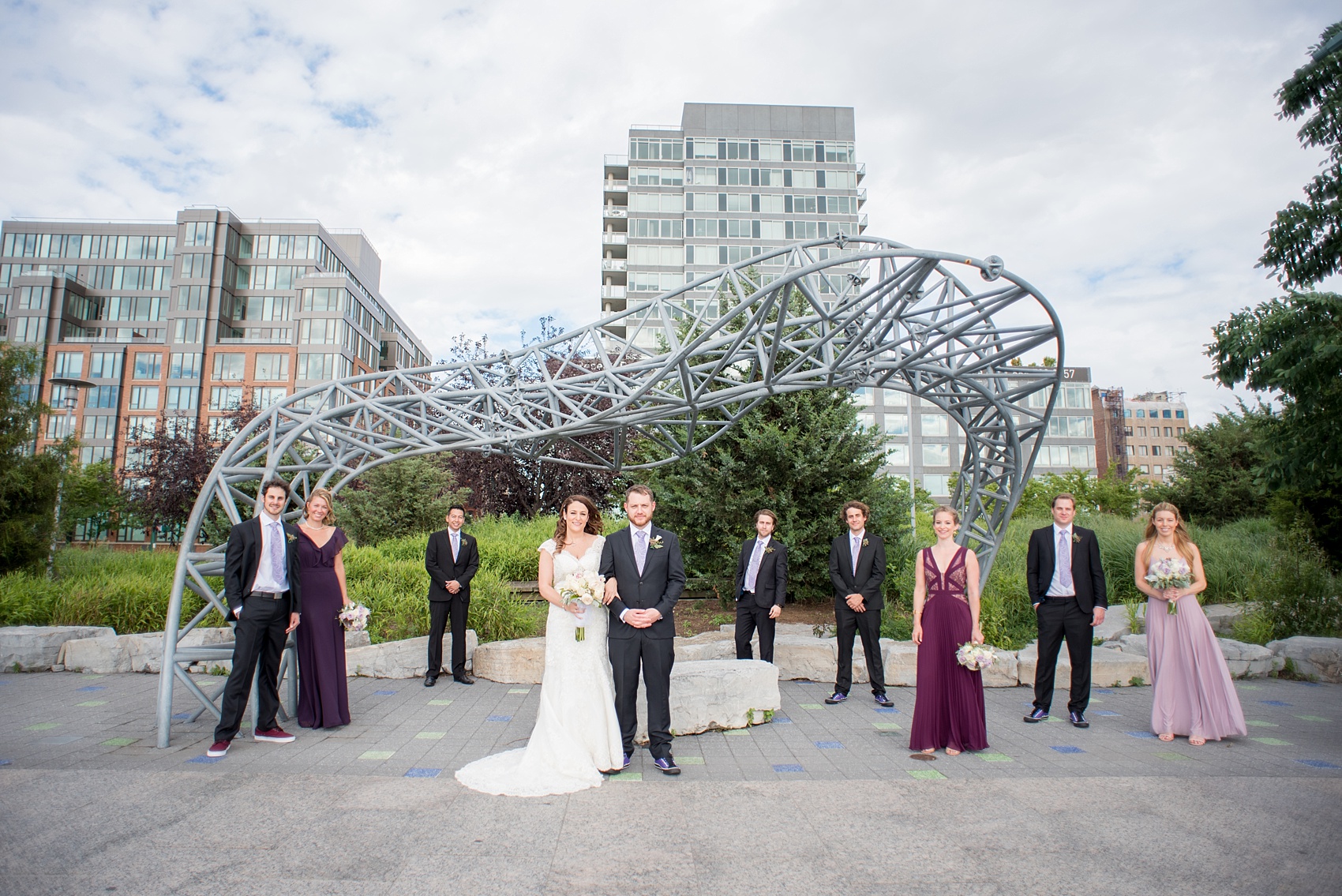 Mikkel Paige Photography photos of a NYC wedding at Tribeca Rooftop. An image of the wedding party/bridal party with a sculpture at Hudson River Park.