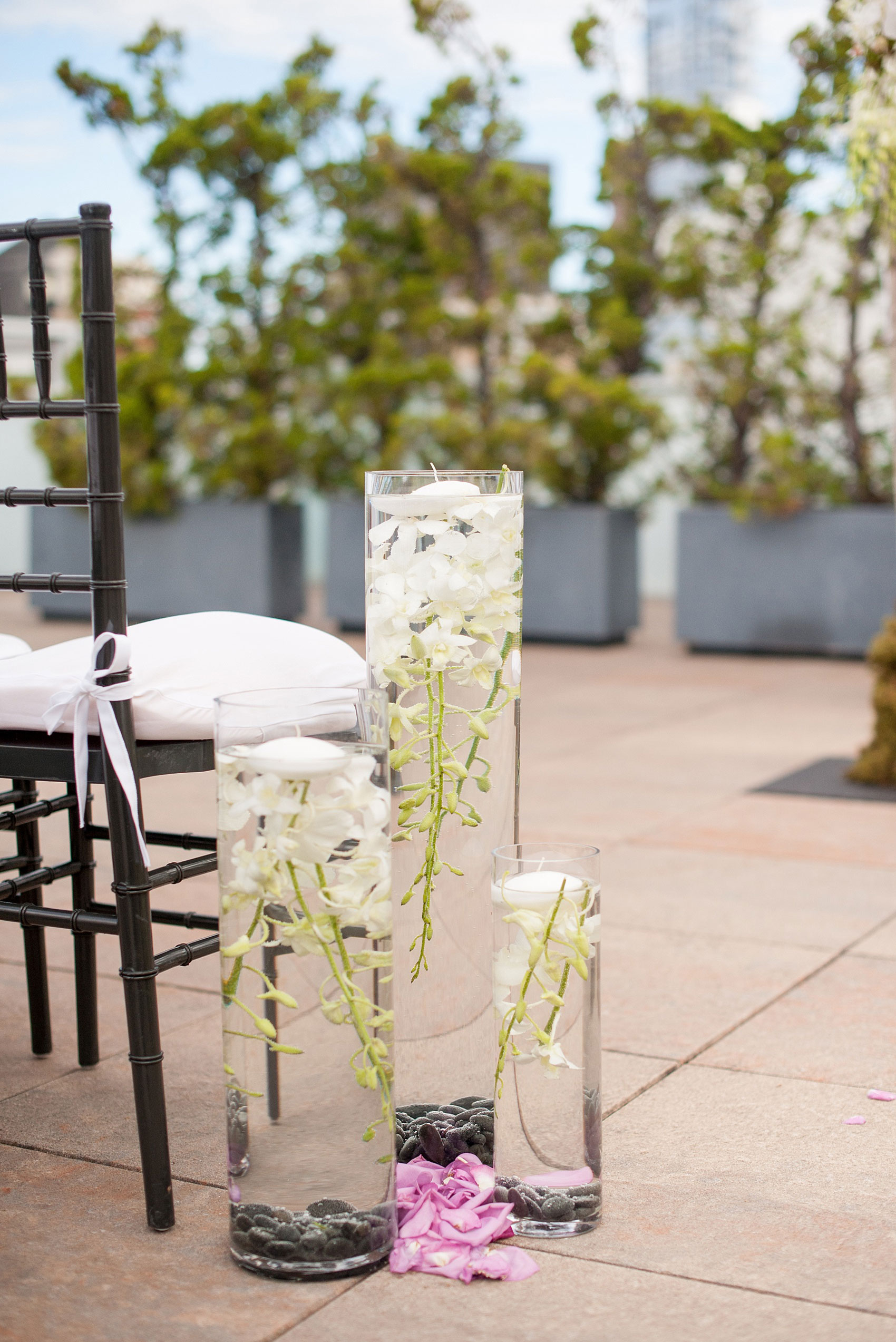 Mikkel Paige Photography photos of a NYC wedding at Tribeca Rooftop. An image of the flowers lining the outdoor ceremony aisles.