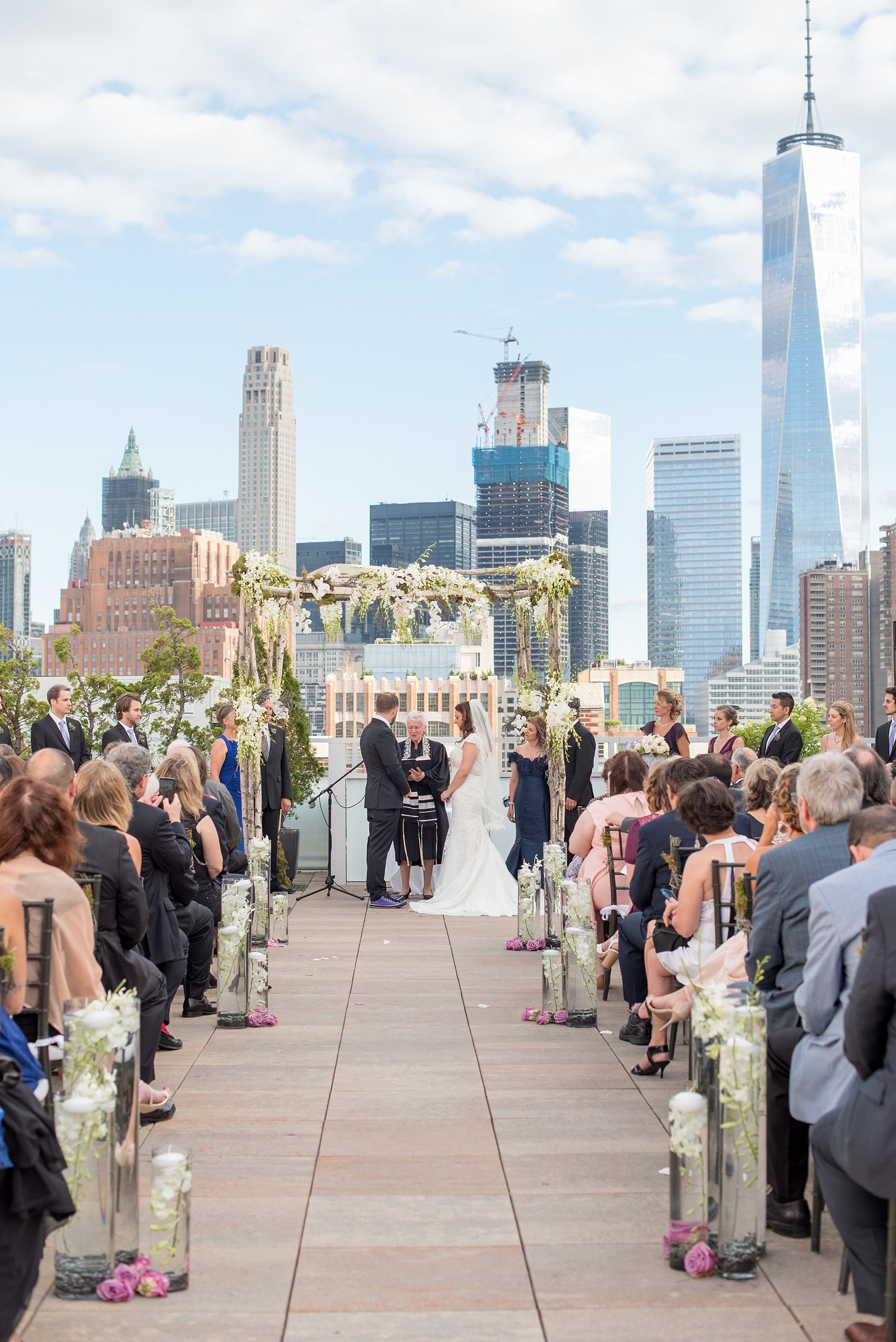 Mikkel Paige Photography photos of a NYC wedding at Tribeca Rooftop. An image of the outdoor ceremony with Freedom Tower in the background.
