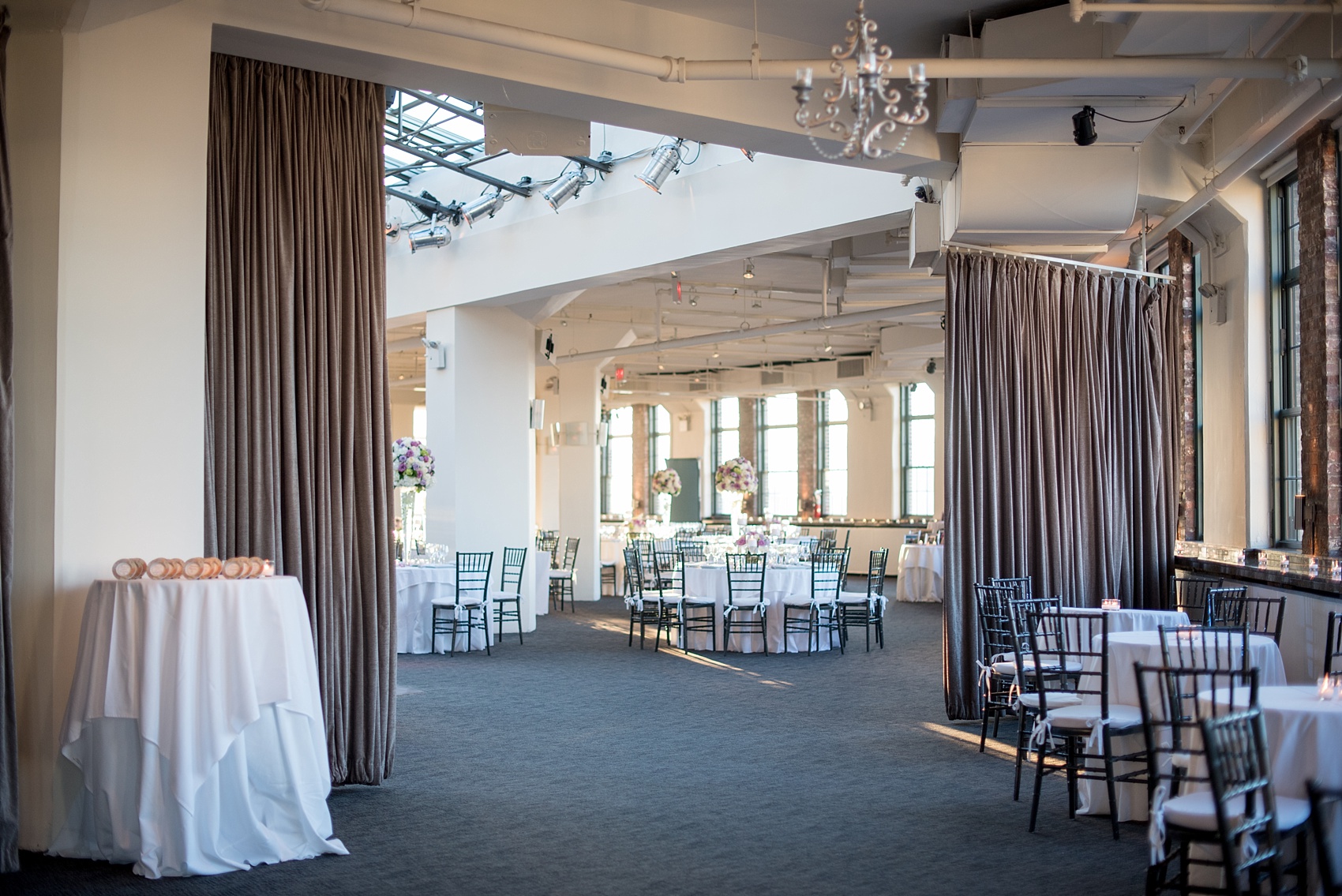 Mikkel Paige Photography photos of a NYC wedding at Tribeca Rooftop. An image of the reception with white linens and purple accents.