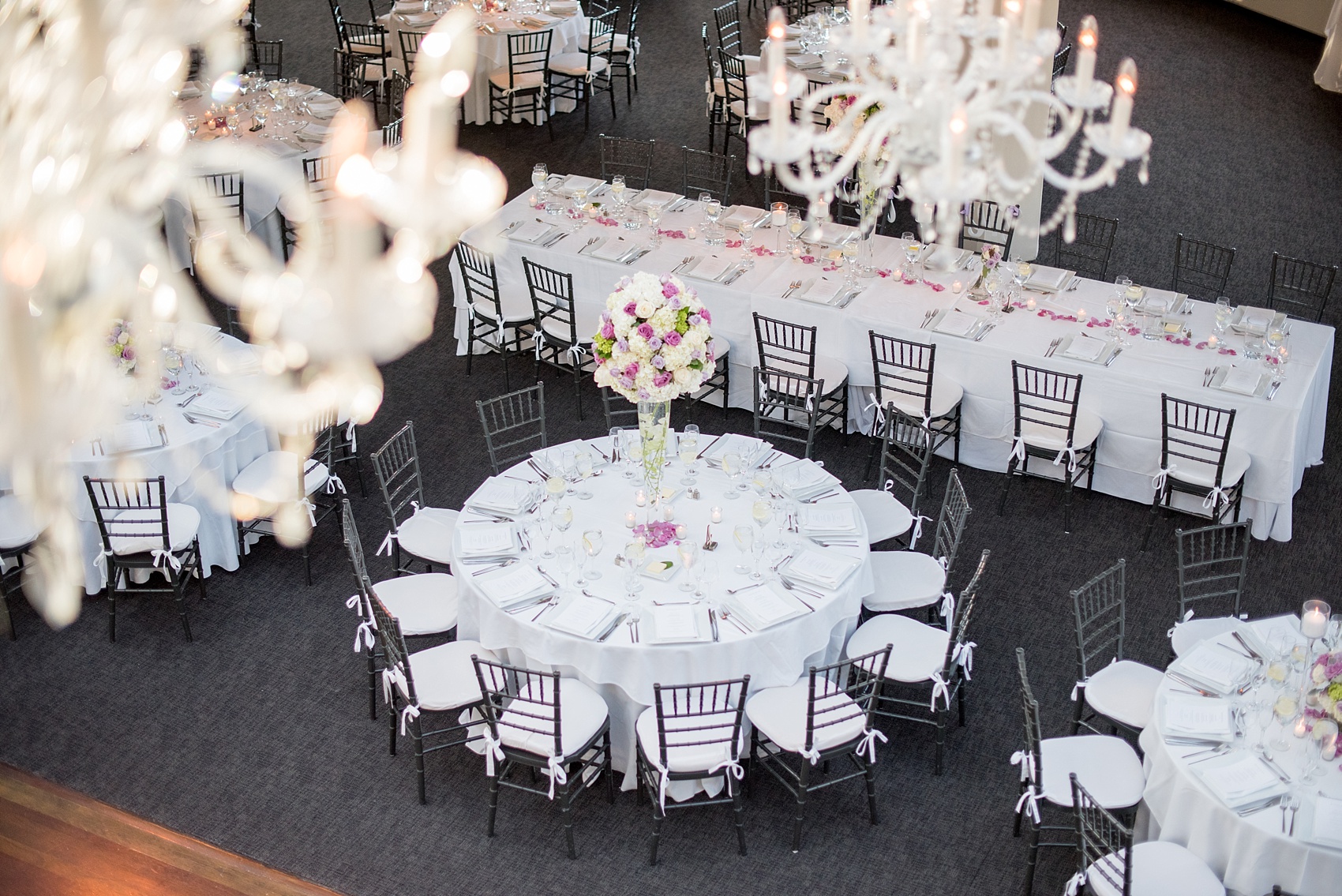 Mikkel Paige Photography photos of a NYC wedding at Tribeca Rooftop. An image of the reception with white linens and purple accents.