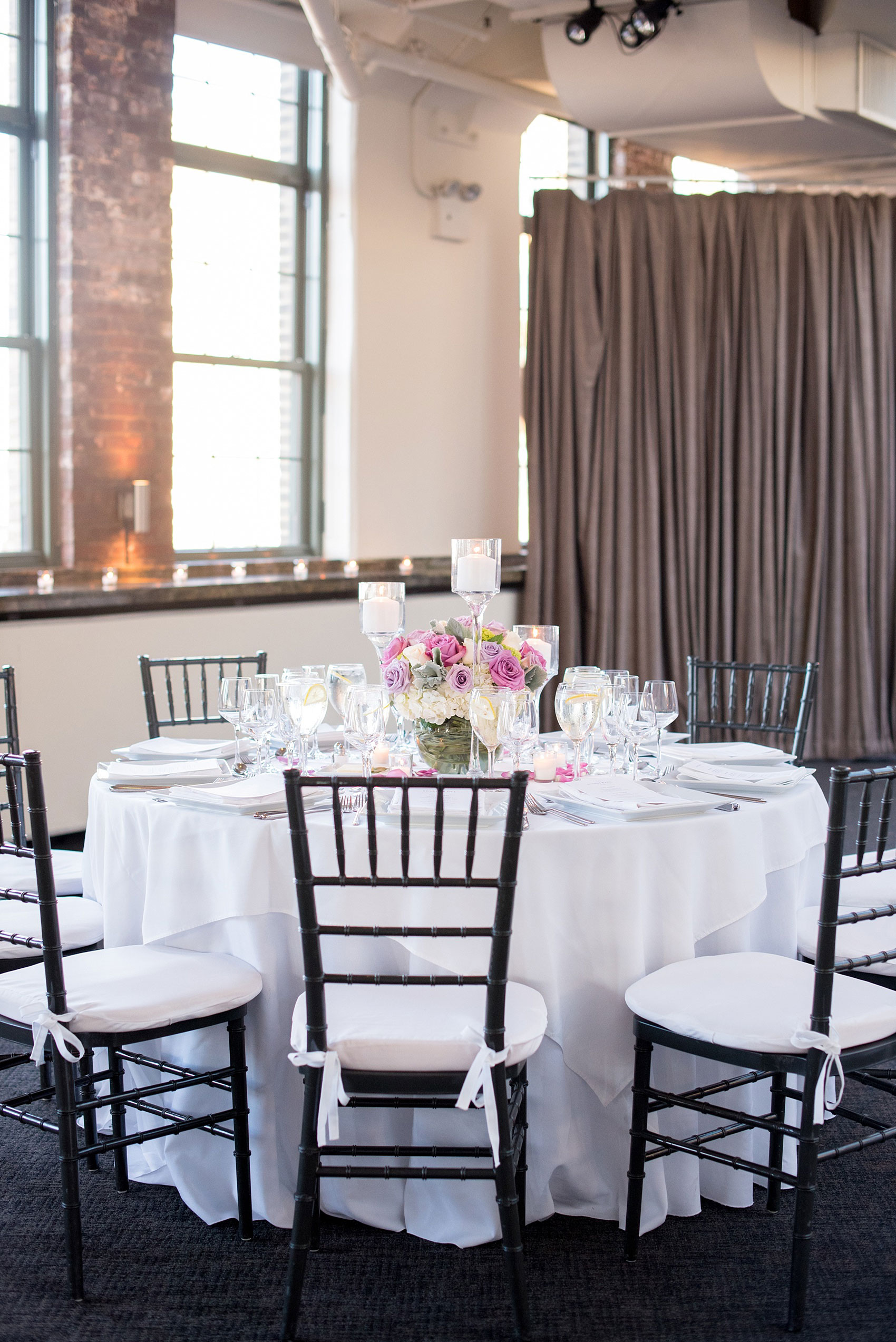 Mikkel Paige Photography photos of a NYC wedding at Tribeca Rooftop. An image of the reception with white linens and purple accents.