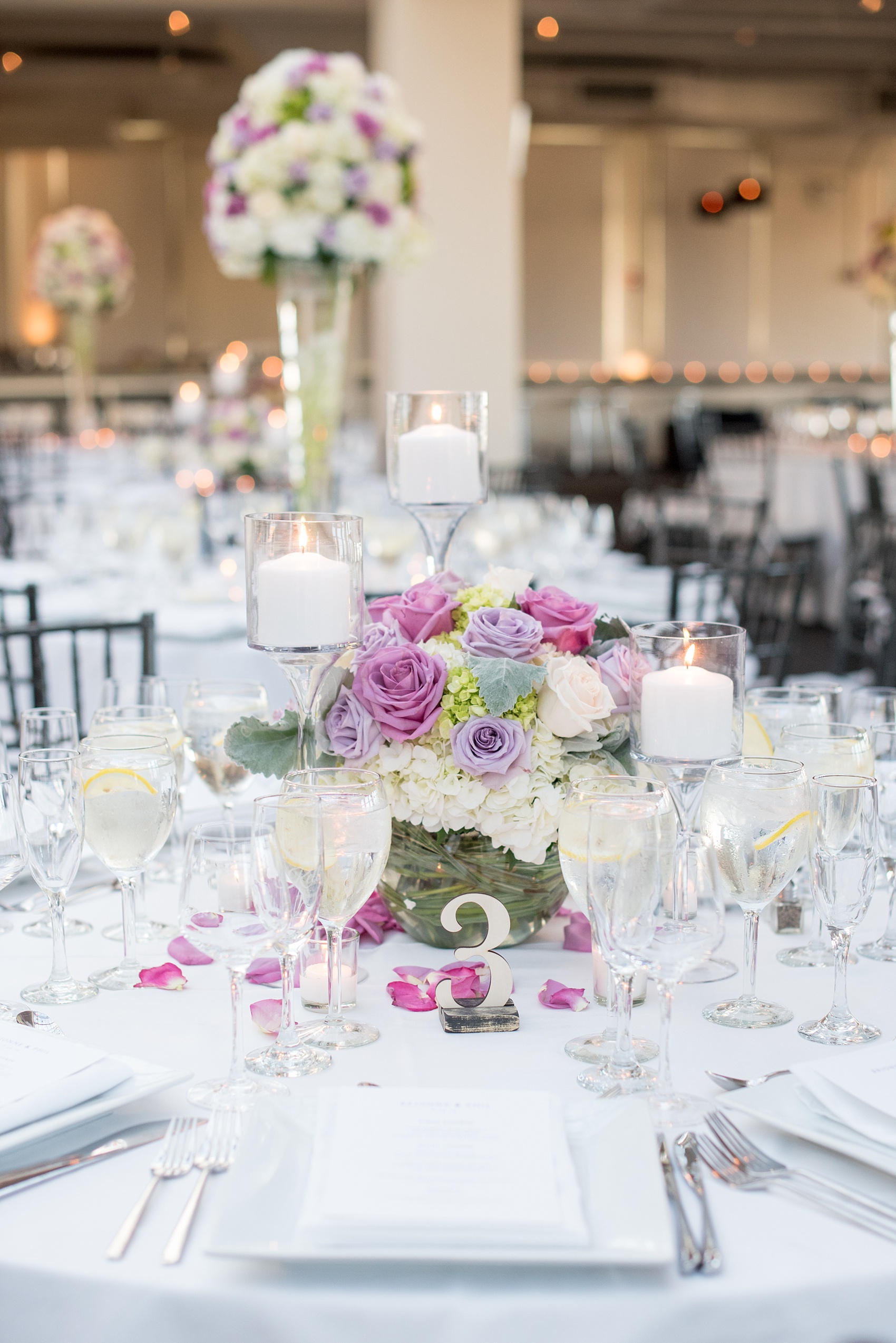 Mikkel Paige Photography photos of a NYC wedding at Tribeca Rooftop. An image of the reception with candlelight and purple flowers.