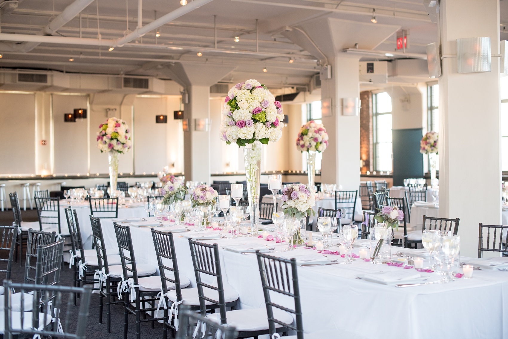 Mikkel Paige Photography photos of a NYC wedding at Tribeca Rooftop. An image of the reception with candlelight and purple flowers.