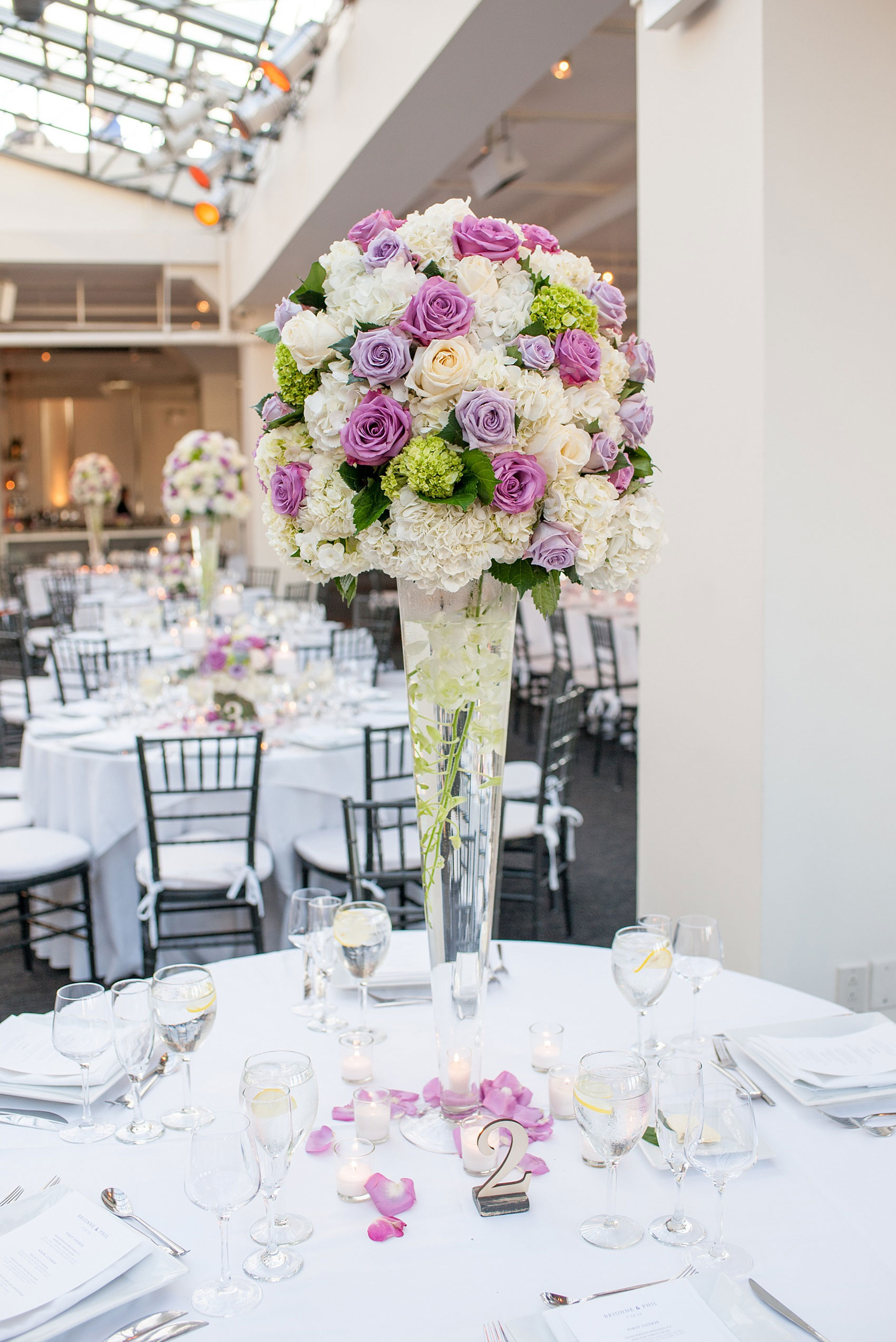 Mikkel Paige Photography photos of a NYC wedding at Tribeca Rooftop. An image of the reception with candlelight and purple flowers.