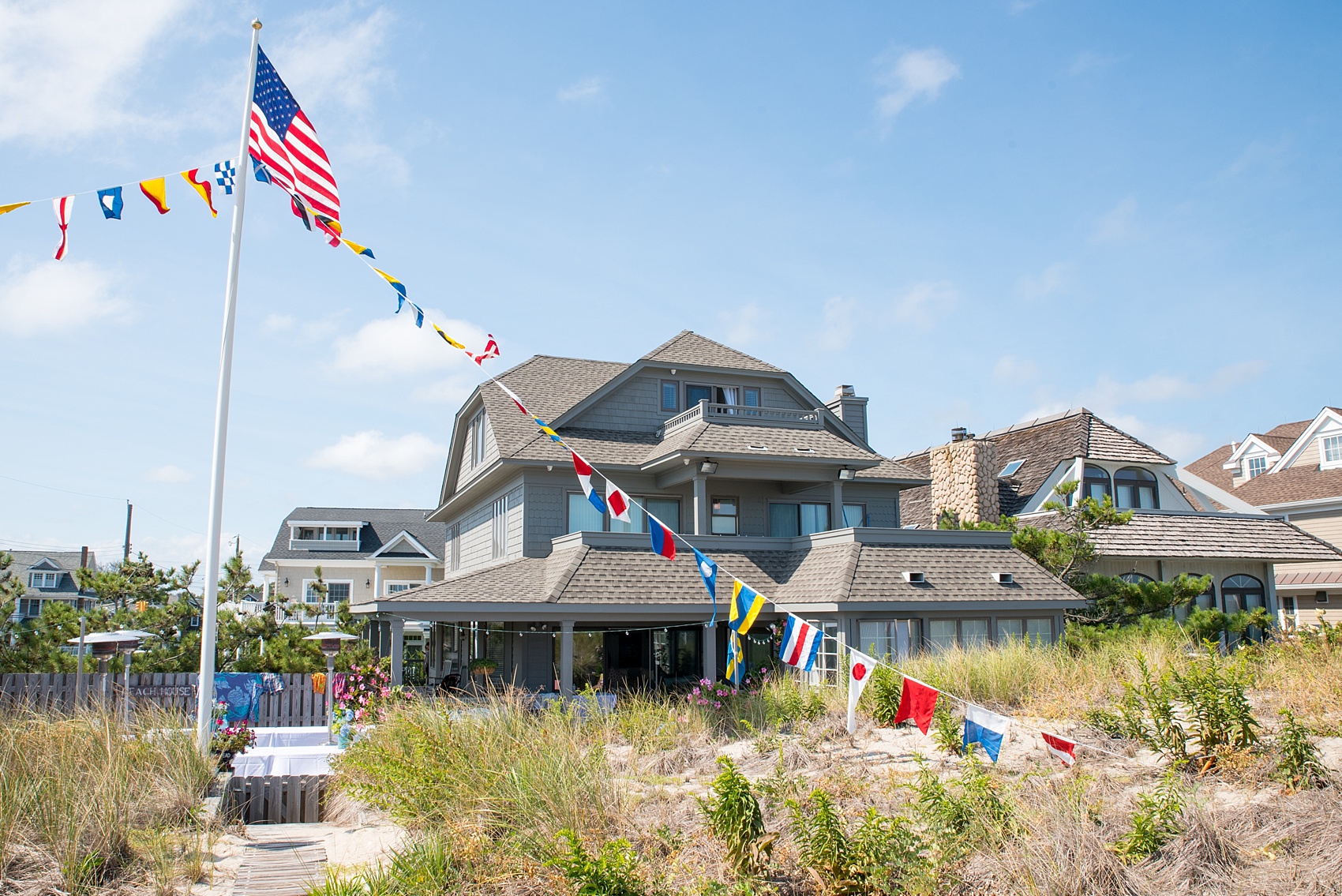 Mikkel Paige Photography photos from a Bay Head Yacht Club wedding in NJ. The groom prepared at his parents beach house complete with nautical flags.