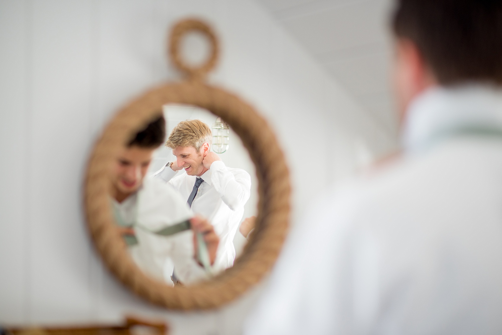 Mikkel Paige Photography photos from a Bay Head Yacht Club wedding in NJ. The groom prepared at his parents beach house in a nautical themed room with a sea rope mirror.