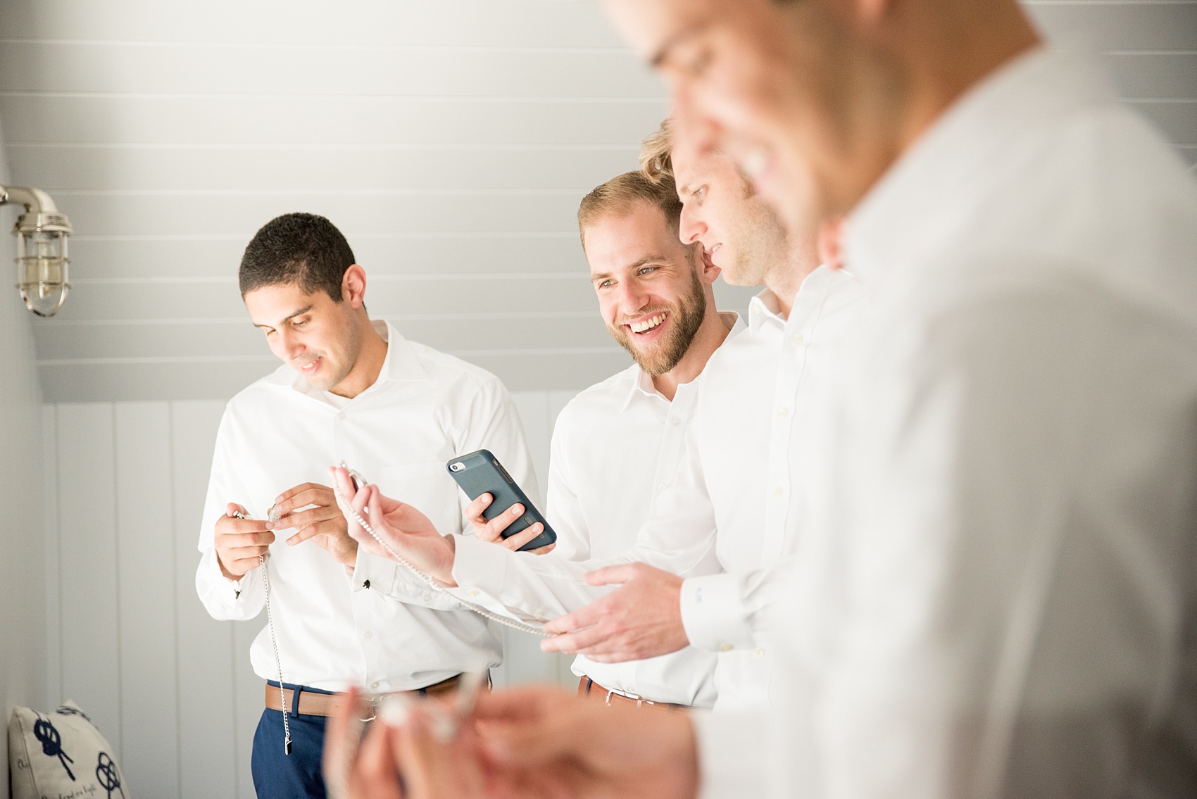 Mikkel Paige Photography photos from a Bay Head Yacht Club wedding in NJ. The groom prepared with his groomsmen at a beach house in a nautical themed room.