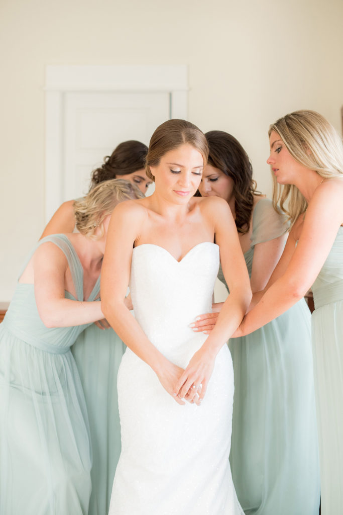 Mikkel Paige Photography photo of a wedding in Bay Head, NJ. The bridesmaids help the bride get ready in mint green chiffon gowns.