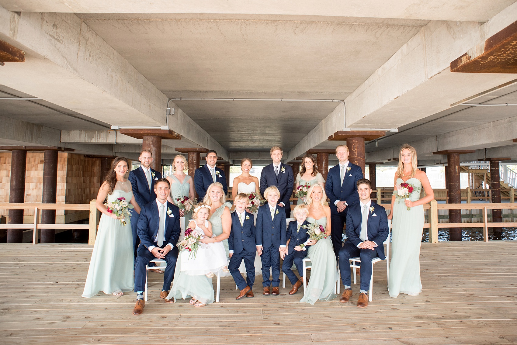 Mikkel Paige Photography photos of a Bay Head Yacht Club nautical wedding. The bride wore a white sweetheart gown and her bridesmaids wore mint green Amsale gowns. The groomsmen wore navy blue suits and grey ties.