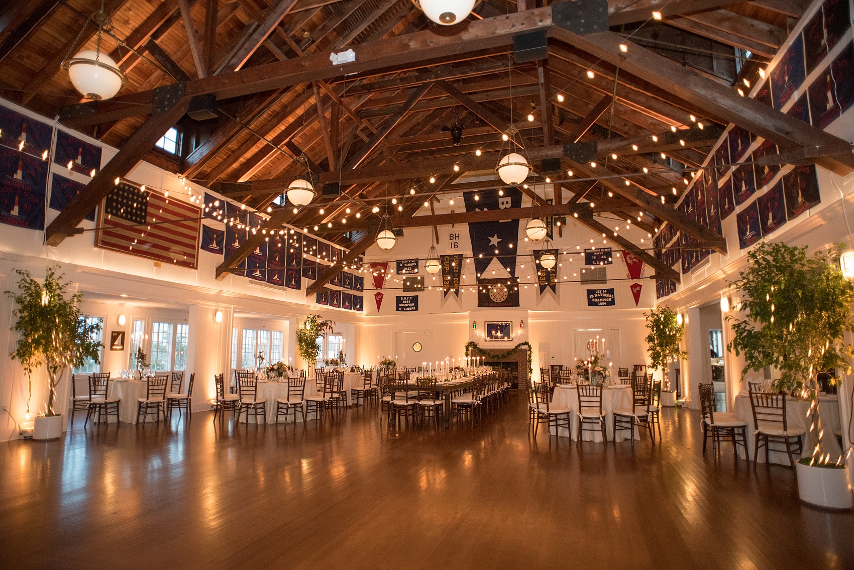 Mikkel Paige Photography picture of a Bay Head Yacht Club nautical wedding. The reception room was decorated with bistro lights, candlelight tables and fall flowers and candelabras.