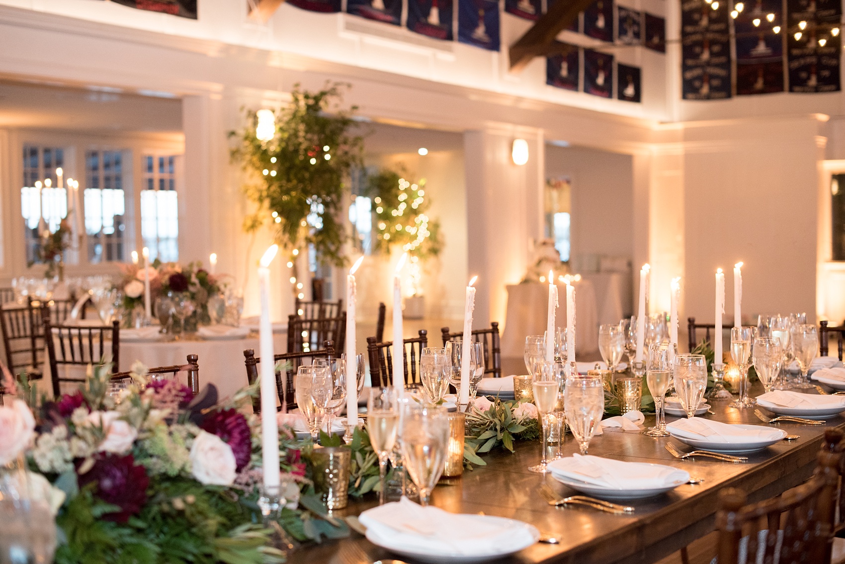 Mikkel Paige Photography picture of a Bay Head Yacht Club nautical wedding. Gold table numbers were help in white rope spheres next to gold flatware with fall colored floral centerpieces and tapered candles.