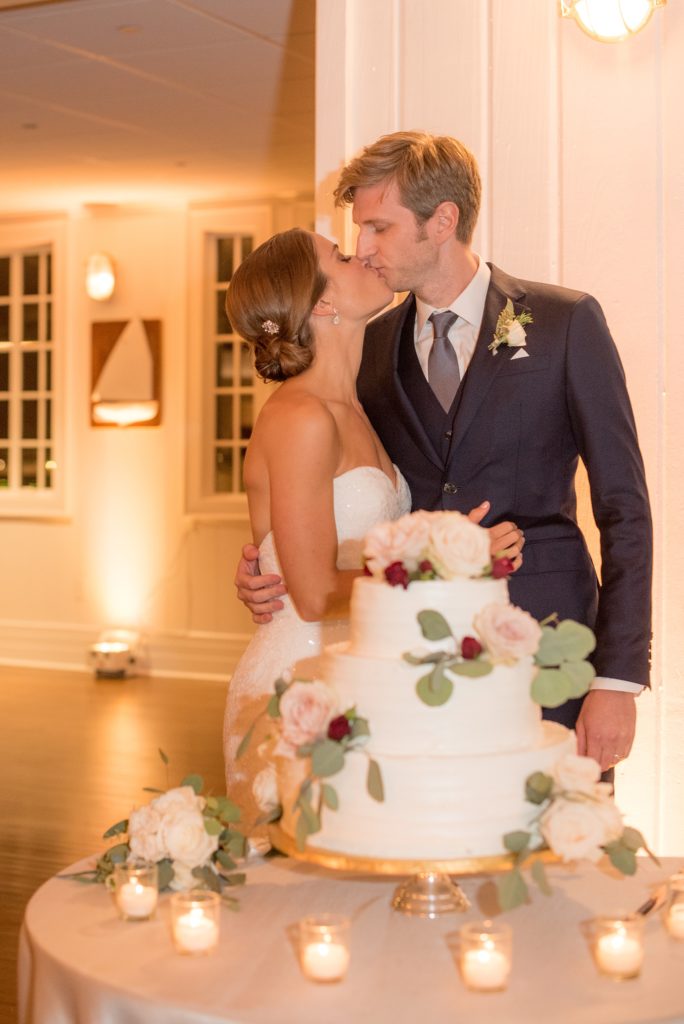 Mikkel Paige Photography photo of the cake cutting at a wedding at Bay Head Yacht Club on the water in New Jersey. White buttercream tiered cake with fall flowers.