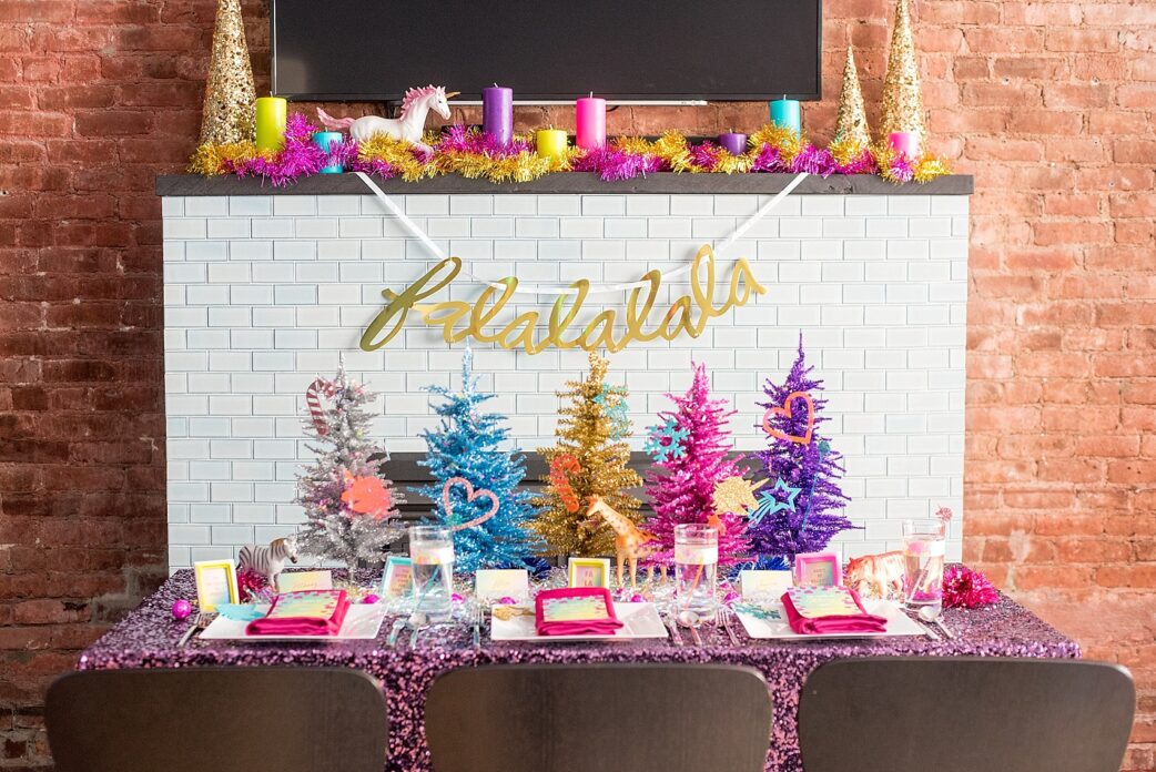 Mikkel Paige Photography photo of a holiday party with a Lisa Frank theme, with a purple sequin tablecloth, colorful Christmas trees, and confetti accents