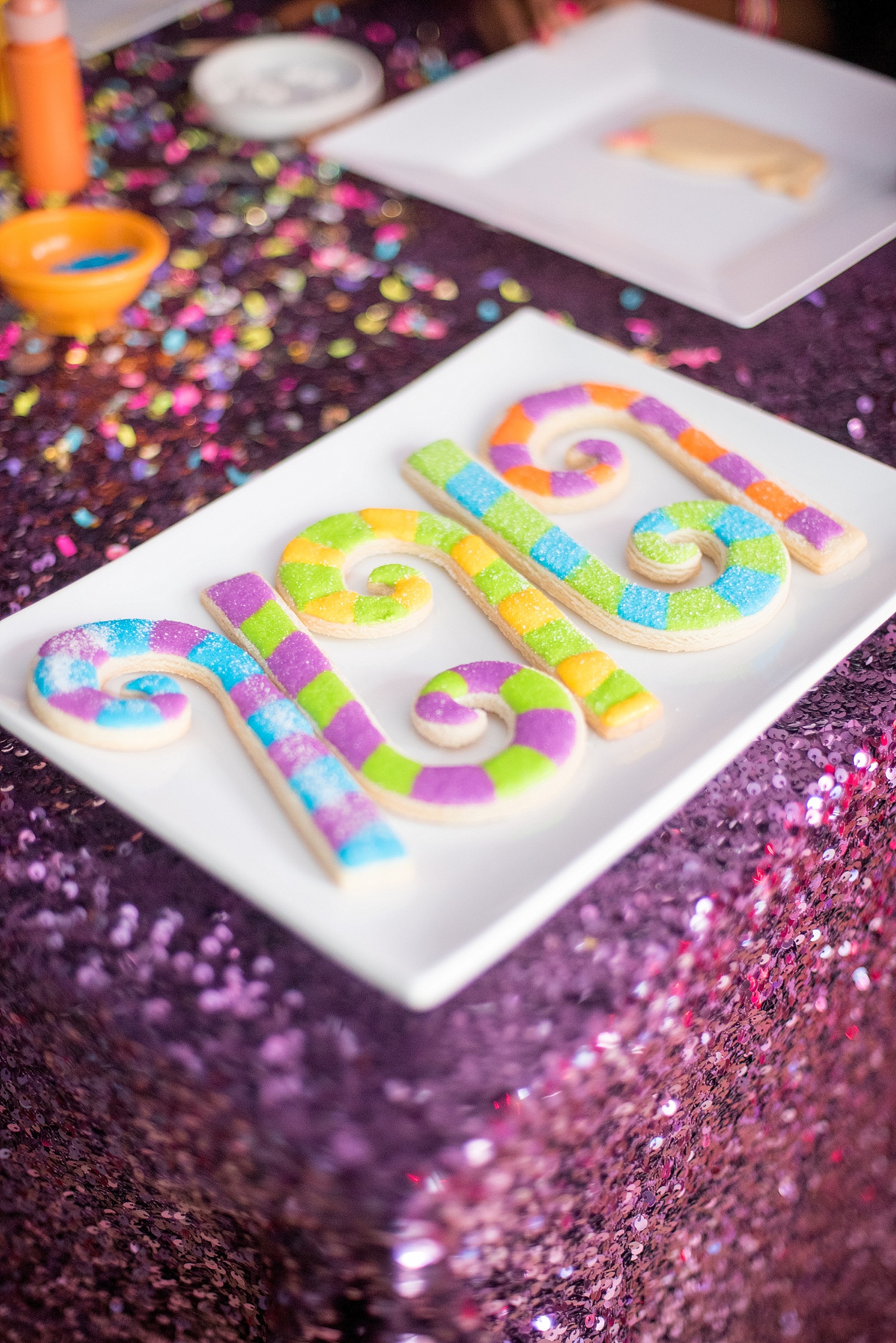 Mikkel Paige Photography photo of a holiday party with a Lisa Frank theme, girlfriend party, with cookie decorating idea, including royal, colorful icing.