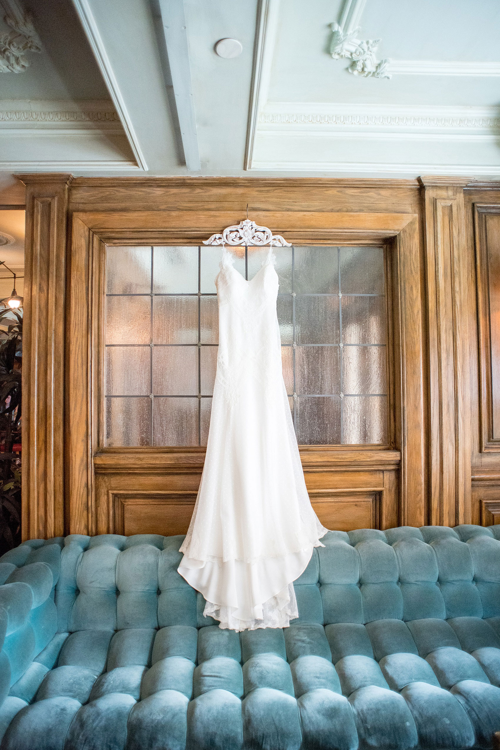 Mikkel Paige Photography captures a luxury wedding in NYC. The bride's David Fielden wedding gown hangs in the lobby of The Marlton Hotel.