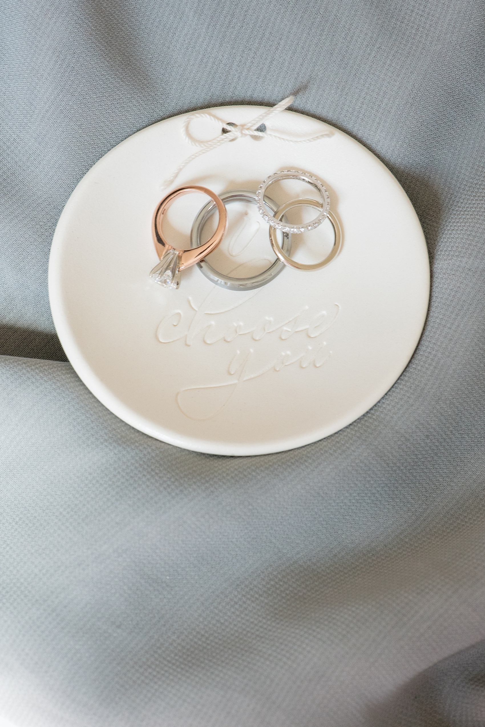 Mikkel Paige Photography photos of a luxury wedding in NYC. Ring dish from BHLDN with "I choose you" and diamond wedding bands and solitaire engagement ring detail picture.