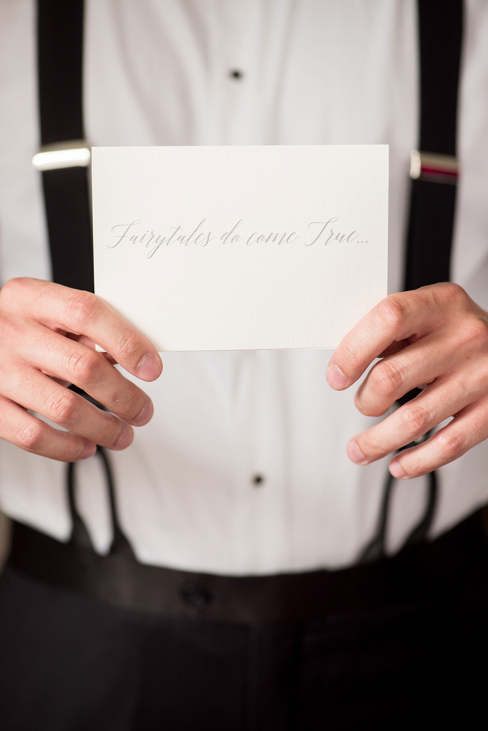 Mikkel Paige Photography photos of a luxury wedding in NYC. Image of the groom holding his "Fairy tales do come true..." calligraphy card.