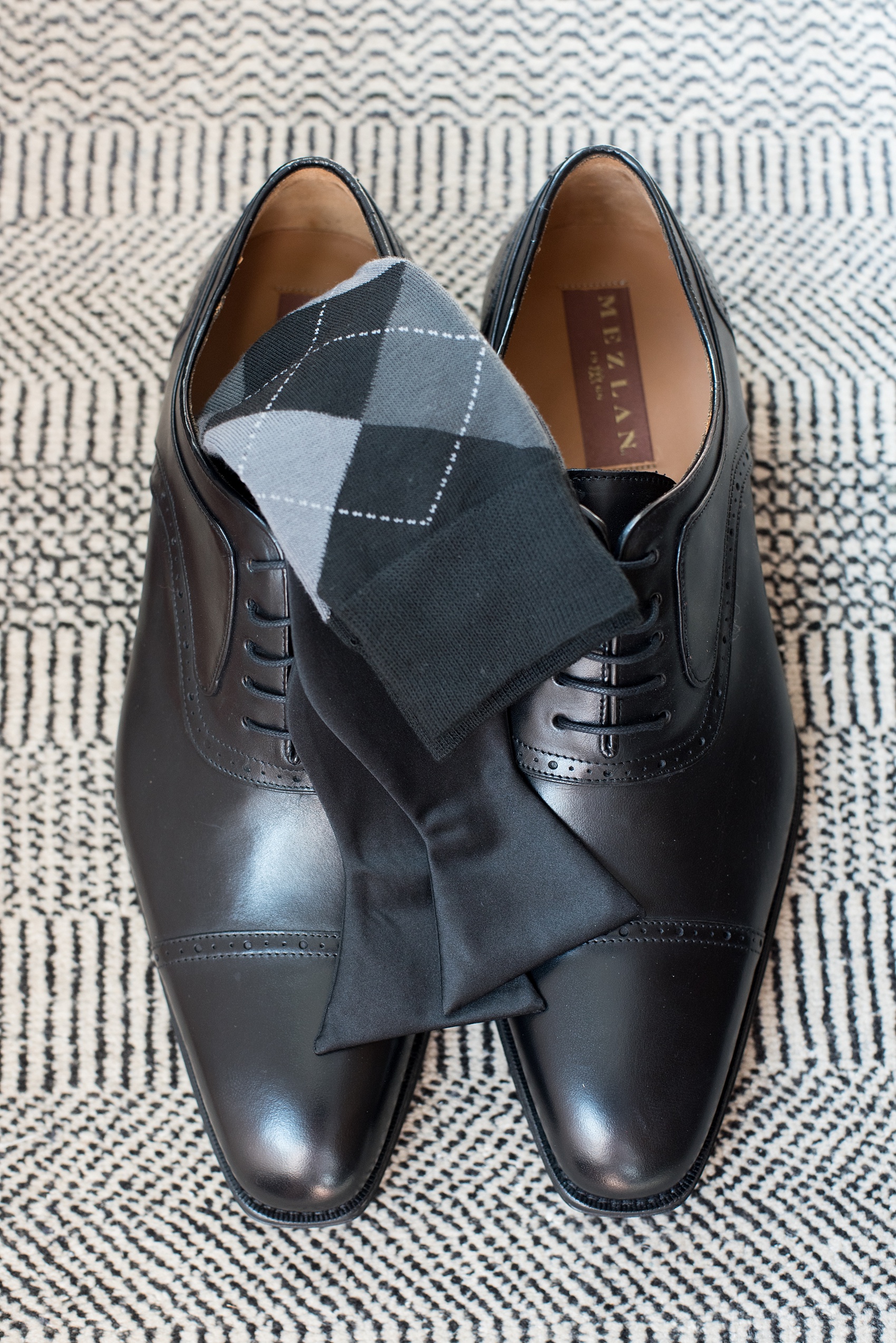 Mikkel Paige Photography photos of a luxury wedding in NYC. Image of the groom's shoes, argyle socks and bow tie at The Marlton Hotel.