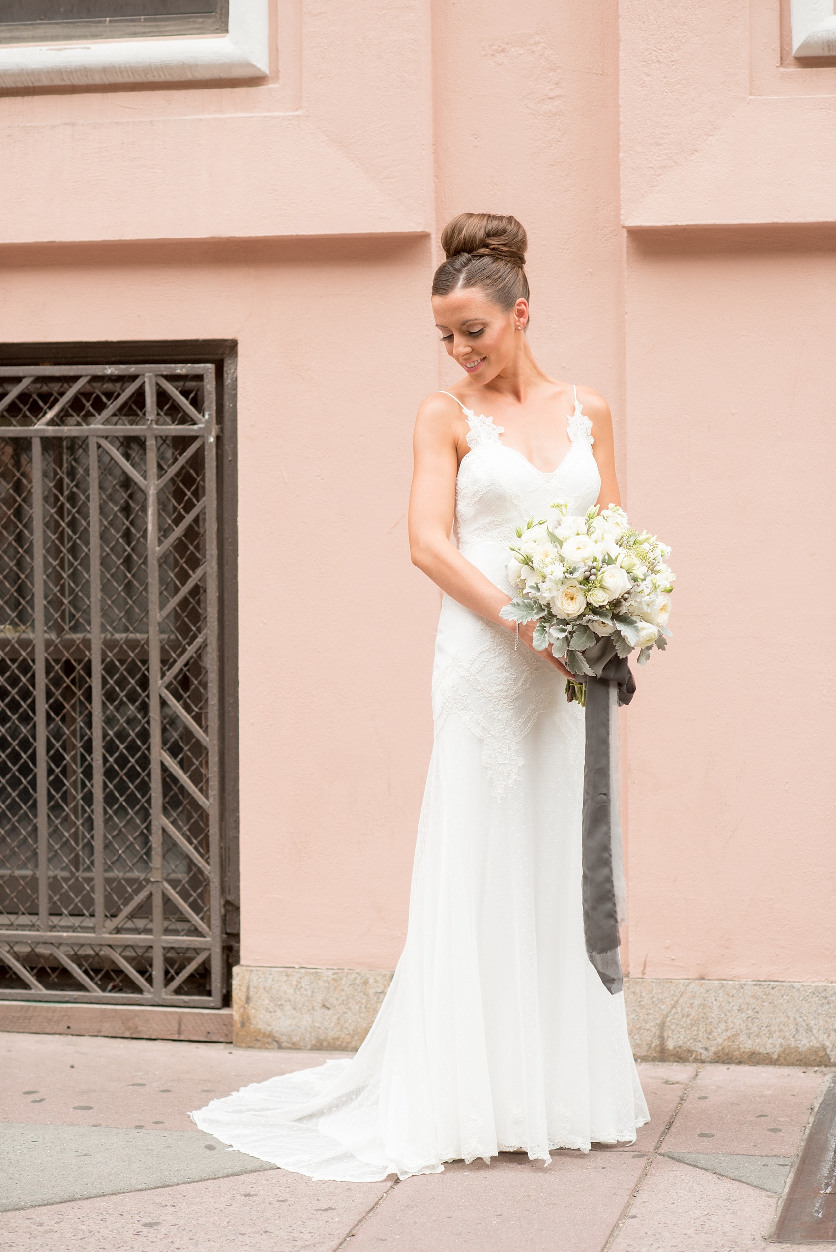 Mikkel Paige Photography photos of a luxury wedding in NYC. Portrait picture of the bride in her form fitting David Fielden wedding gown from Kleinfeld's, holding her white bouquet.