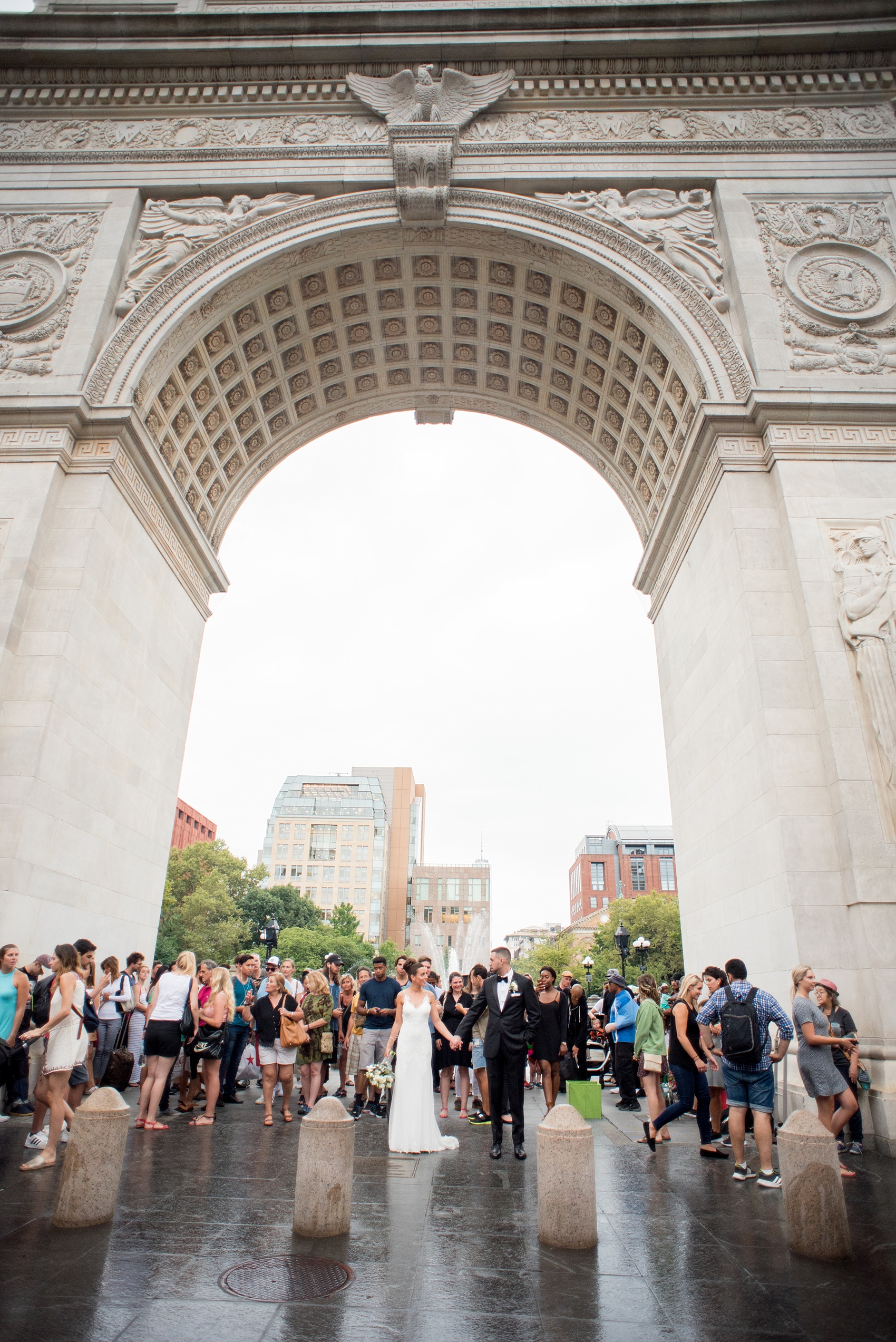 Mikkel Paige Photography photos of a luxury wedding in NYC. Image of the bride and groom in Washington Square Park under the iconic arch in the rain.