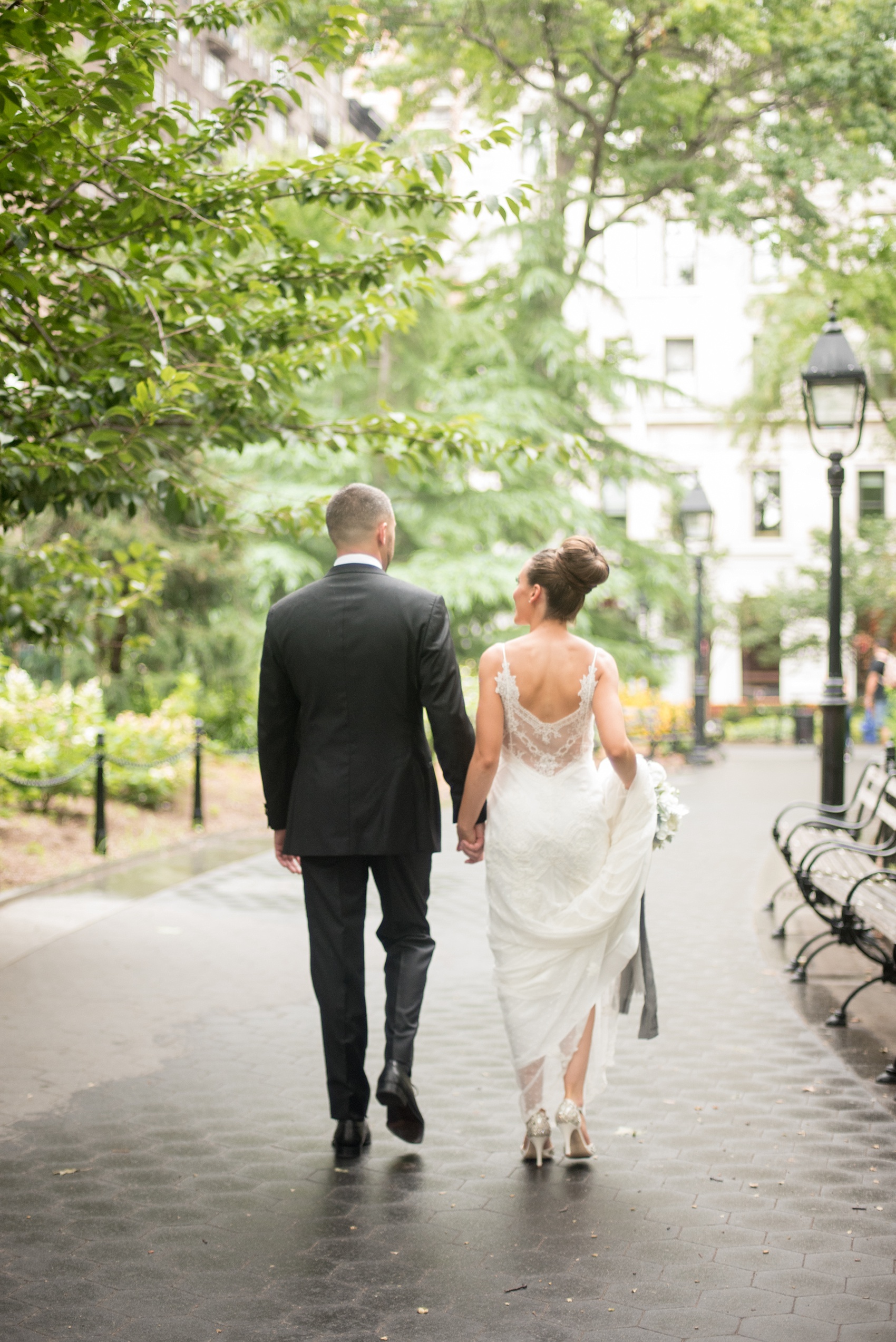 Mikkel Paige Photography photos of a luxury wedding in NYC. Image of the bride and groom walking in Washington Square Park.