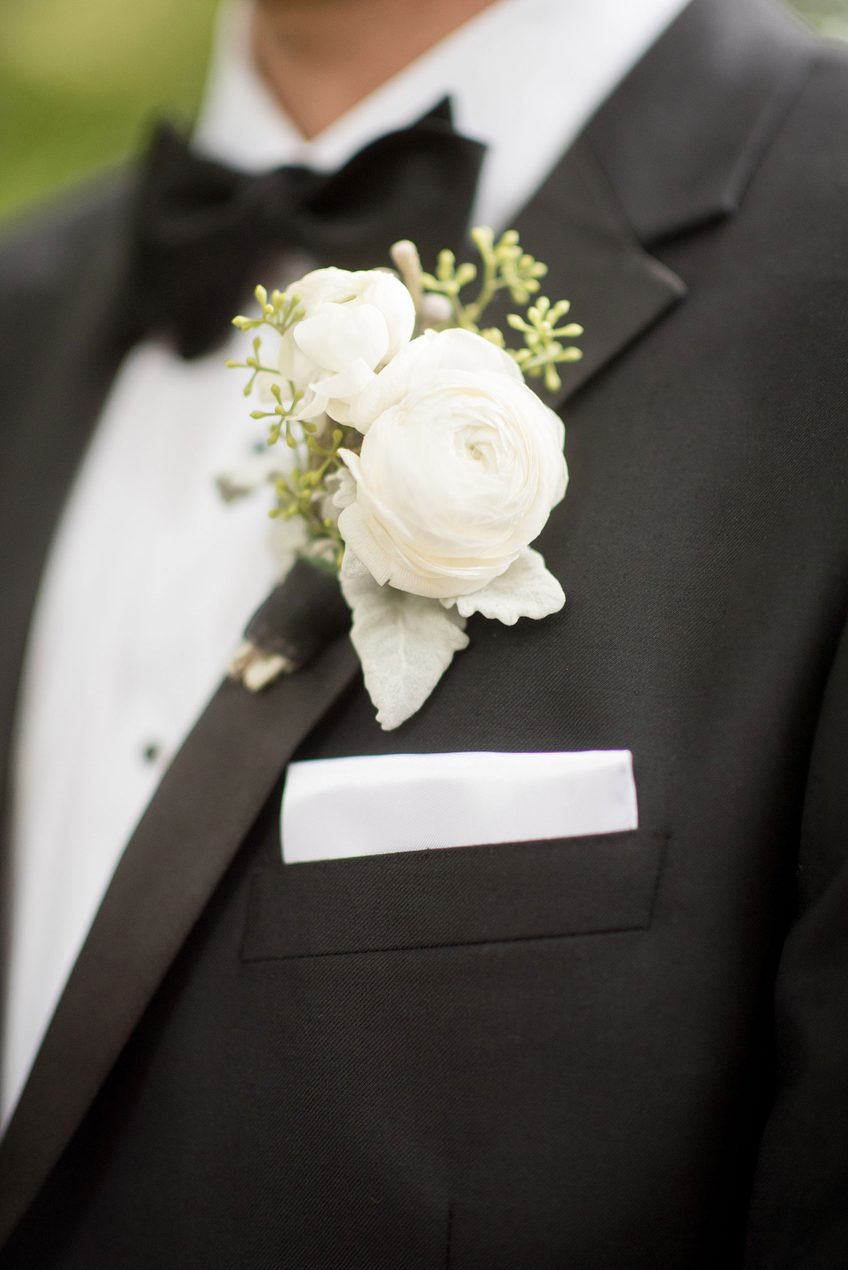 Mikkel Paige Photography photos of a luxury wedding in NYC. Image of the groom's white ranunculus boutonniere.