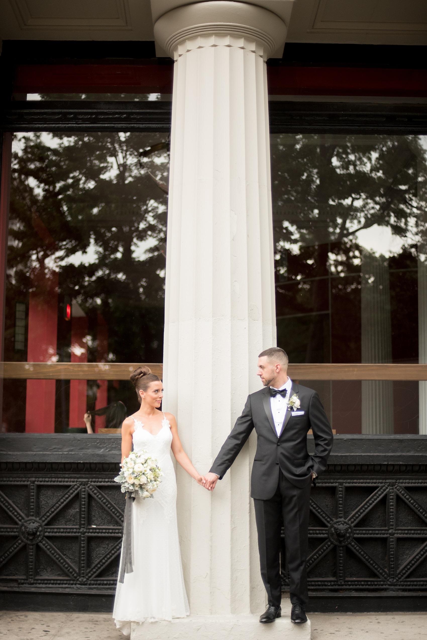 Mikkel Paige Photography photos of a luxury wedding in NYC. Image of the bride and groom near Washington Square Park with white columns.