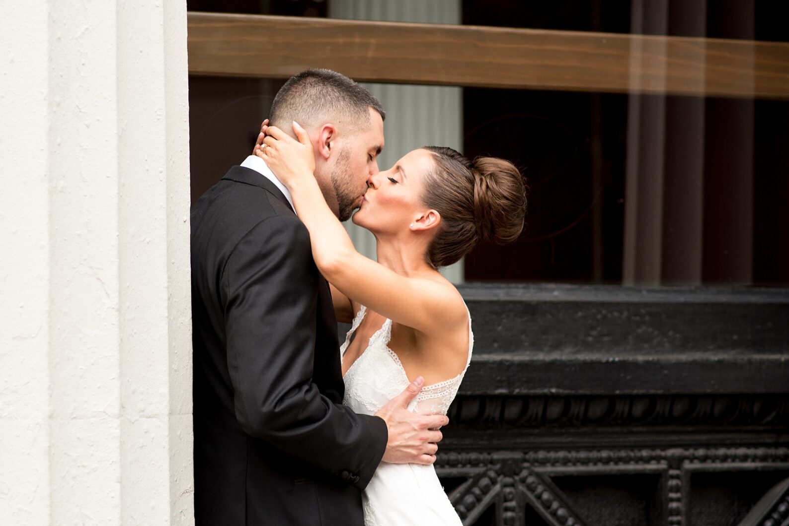 Mikkel Paige Photography photos of a luxury wedding in NYC. Image of the bride and groom near Washington Square Park kissing between white columns.