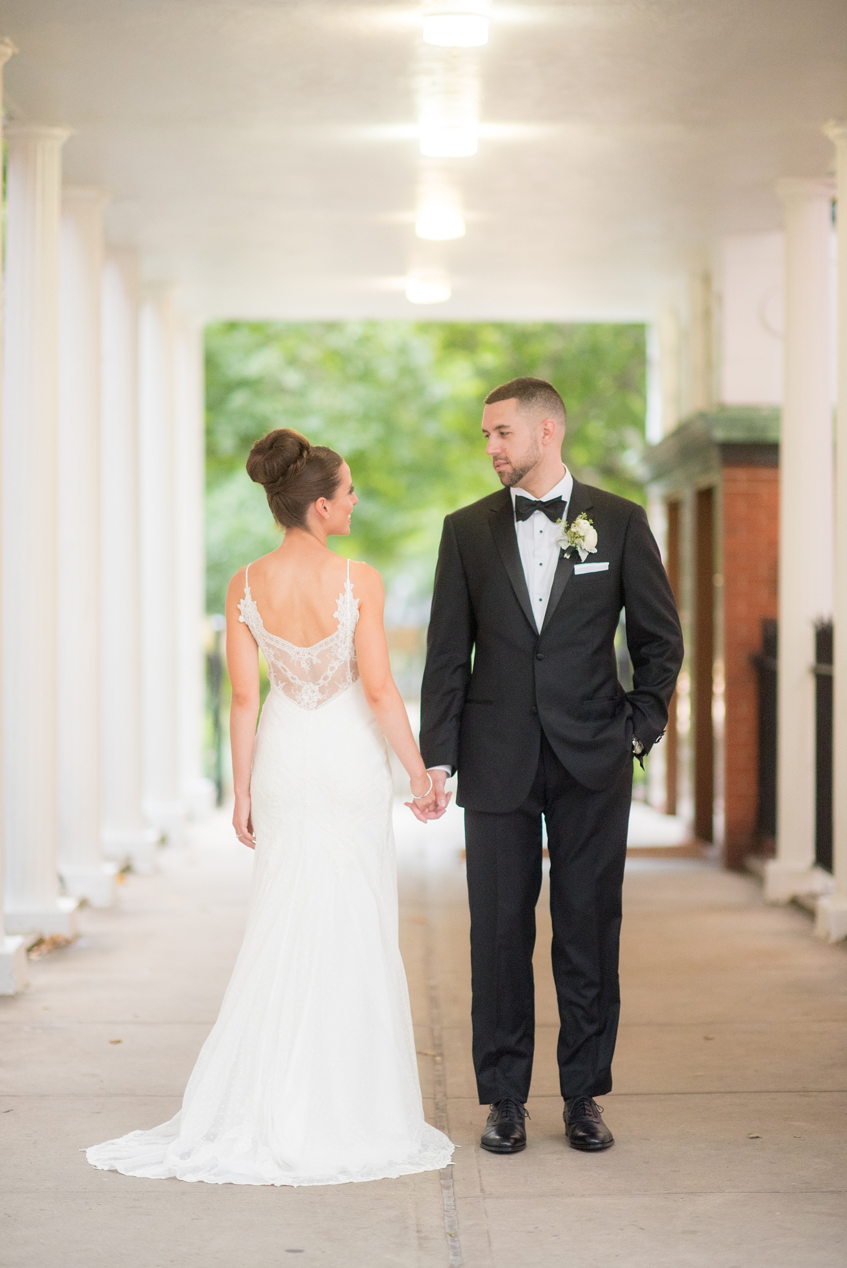 Mikkel Paige Photography photos of a luxury wedding in NYC. Image of the bride and groom near Washington Square Park between white columns.