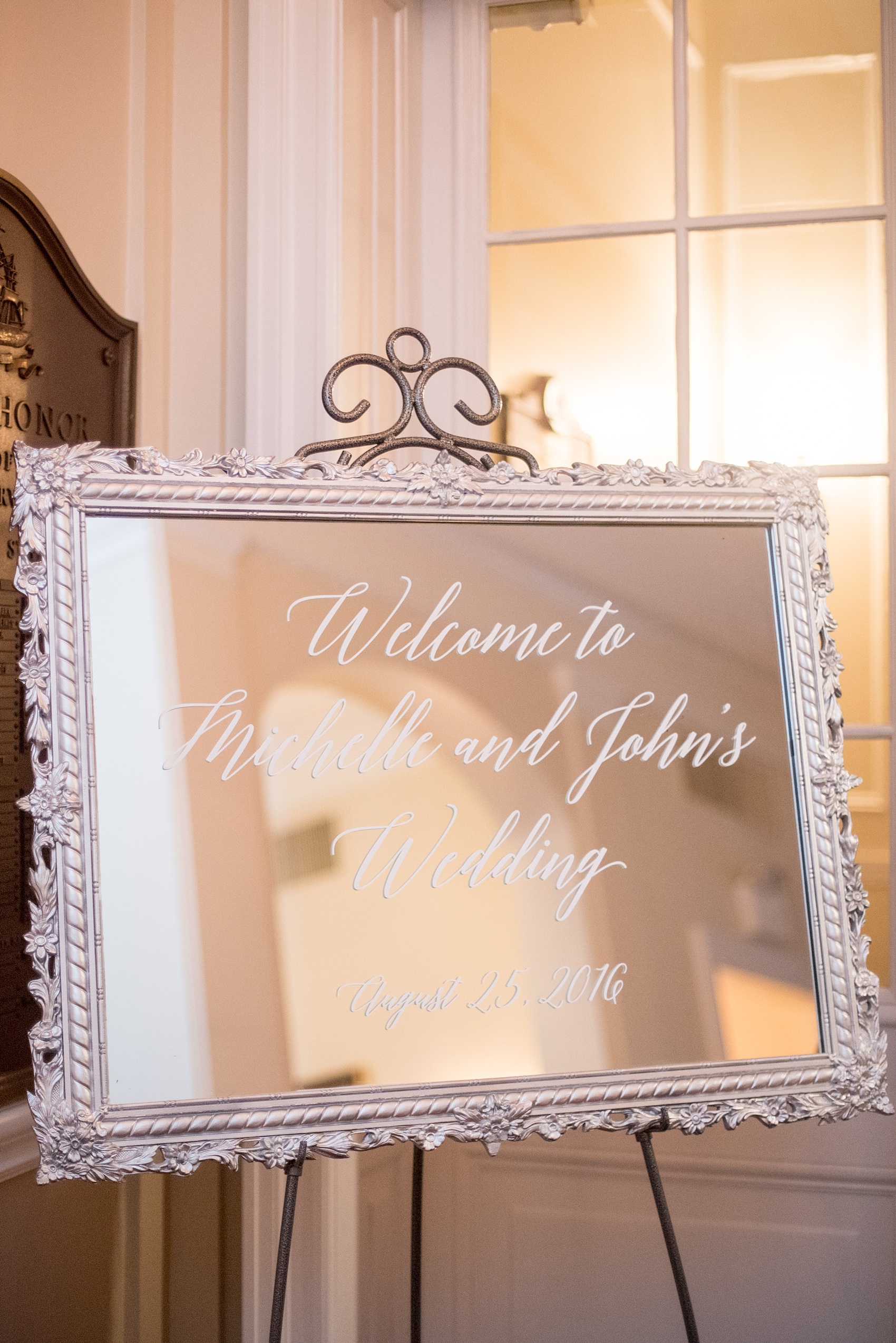 Mikkel Paige Photography photos of a luxury wedding in NYC. Image of the bride and groom's welcome sign, calligraphy on a framed mirror, in India House in lower Manhattan.