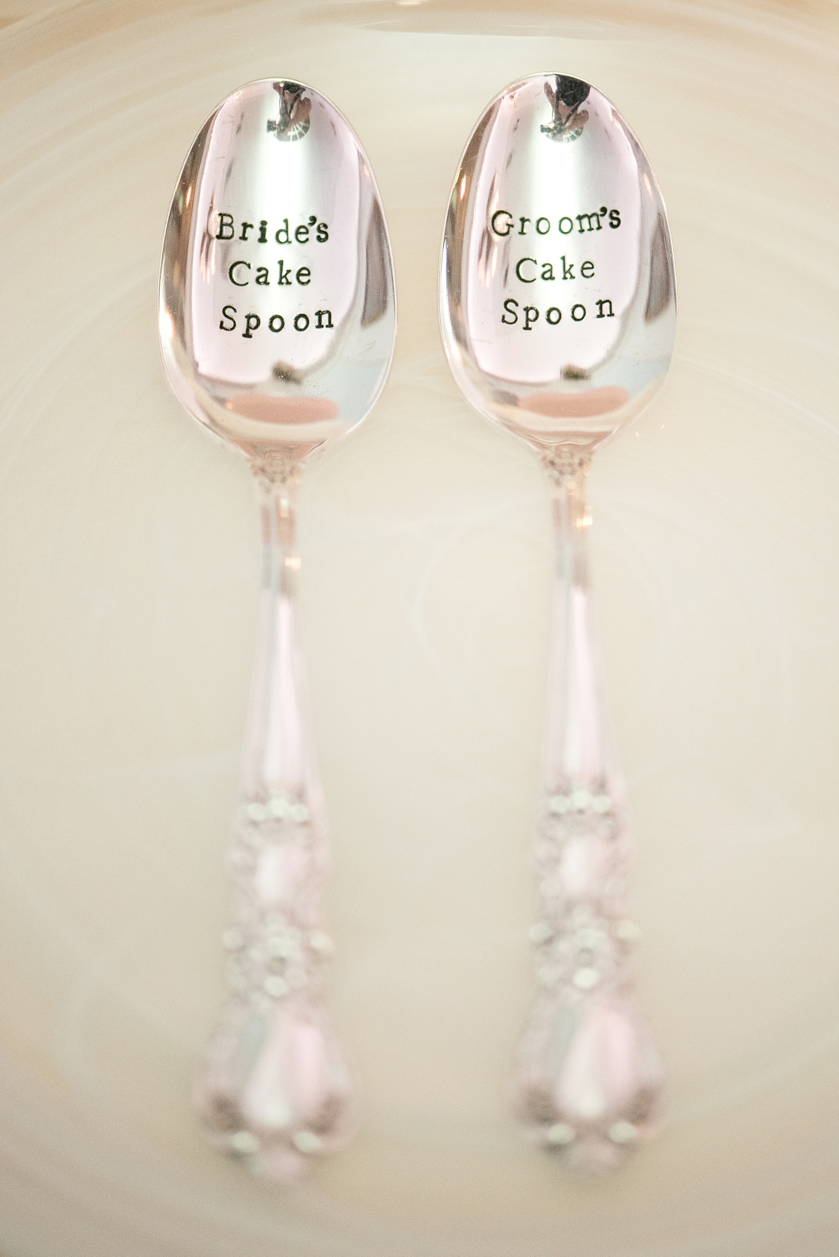 Mikkel Paige Photography photos of a luxury wedding in NYC. Image of couple's custom cake cutting spoons.