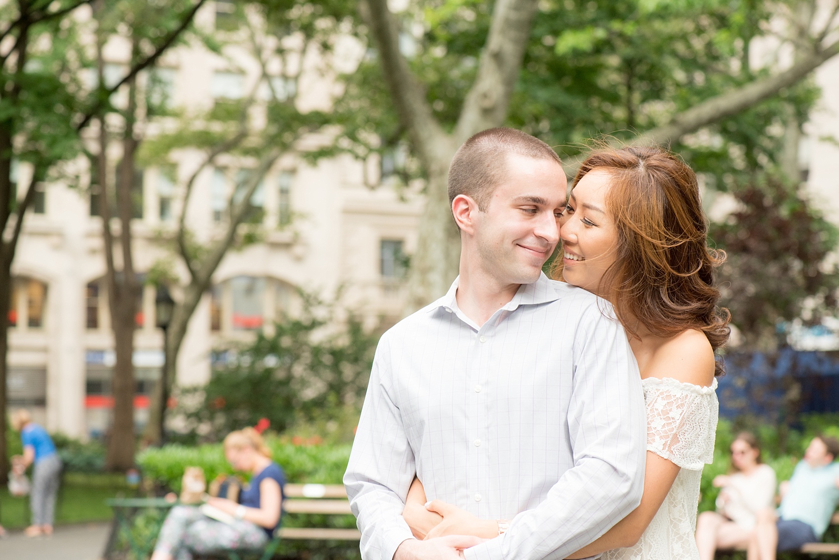 Mikkel Paige Photography photos of a Madison Square Park engagement session in NYC during spring. The bride wore an off-the-shoulder white lace top and orange shorts.