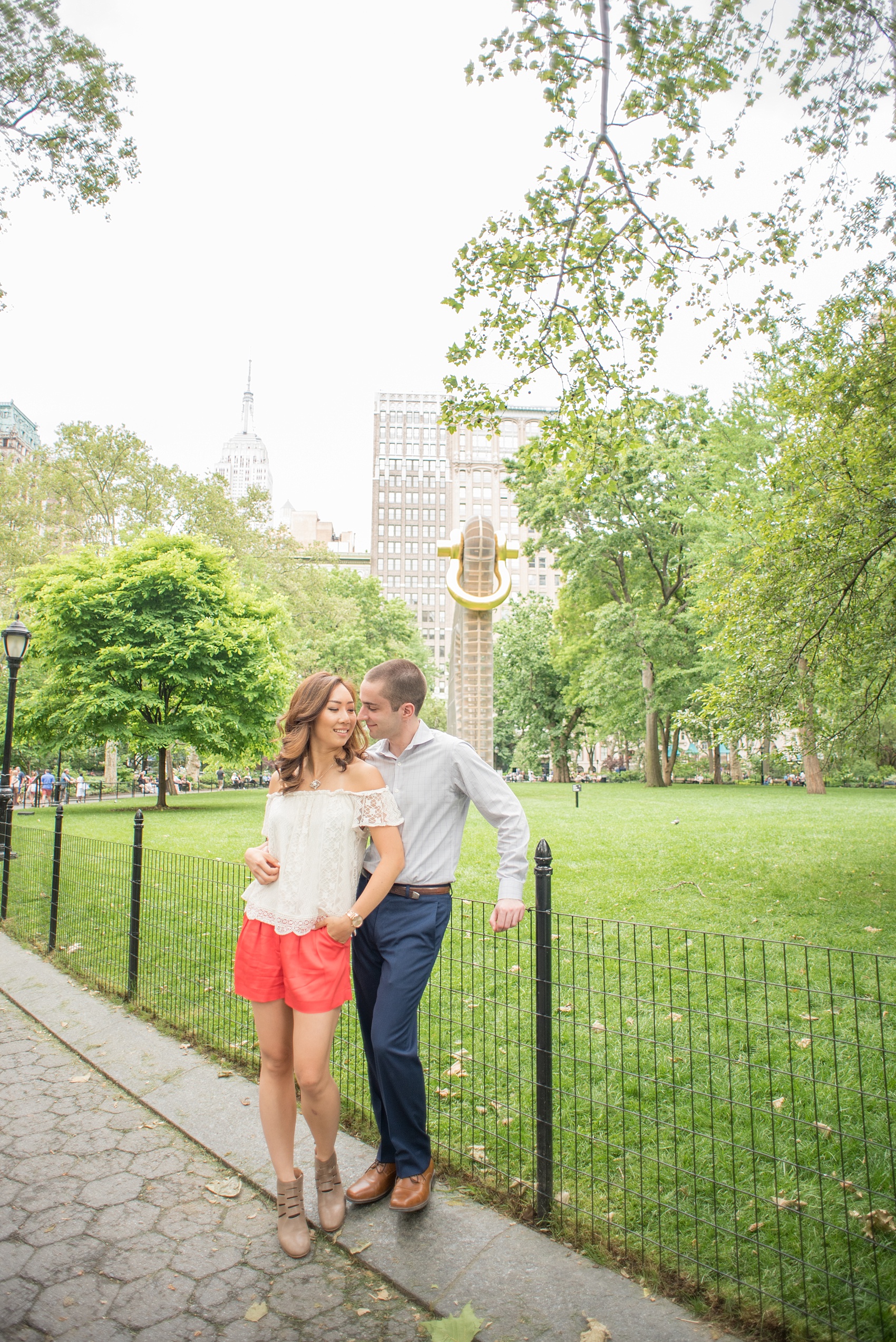 Mikkel Paige Photography photos of a Madison Square Park engagement session in NYC during spring. The bride and groom with the Empire State Building in the background. 