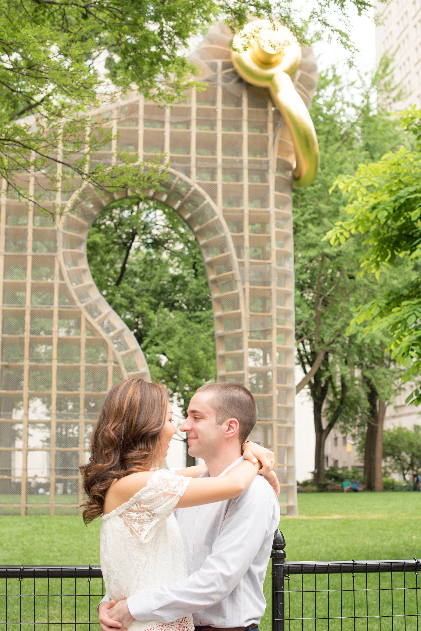 Mikkel Paige Photography photos of a Madison Square Park engagement session in NYC during spring. The bride wore an off-the-shoulder white lace top and orange shorts.