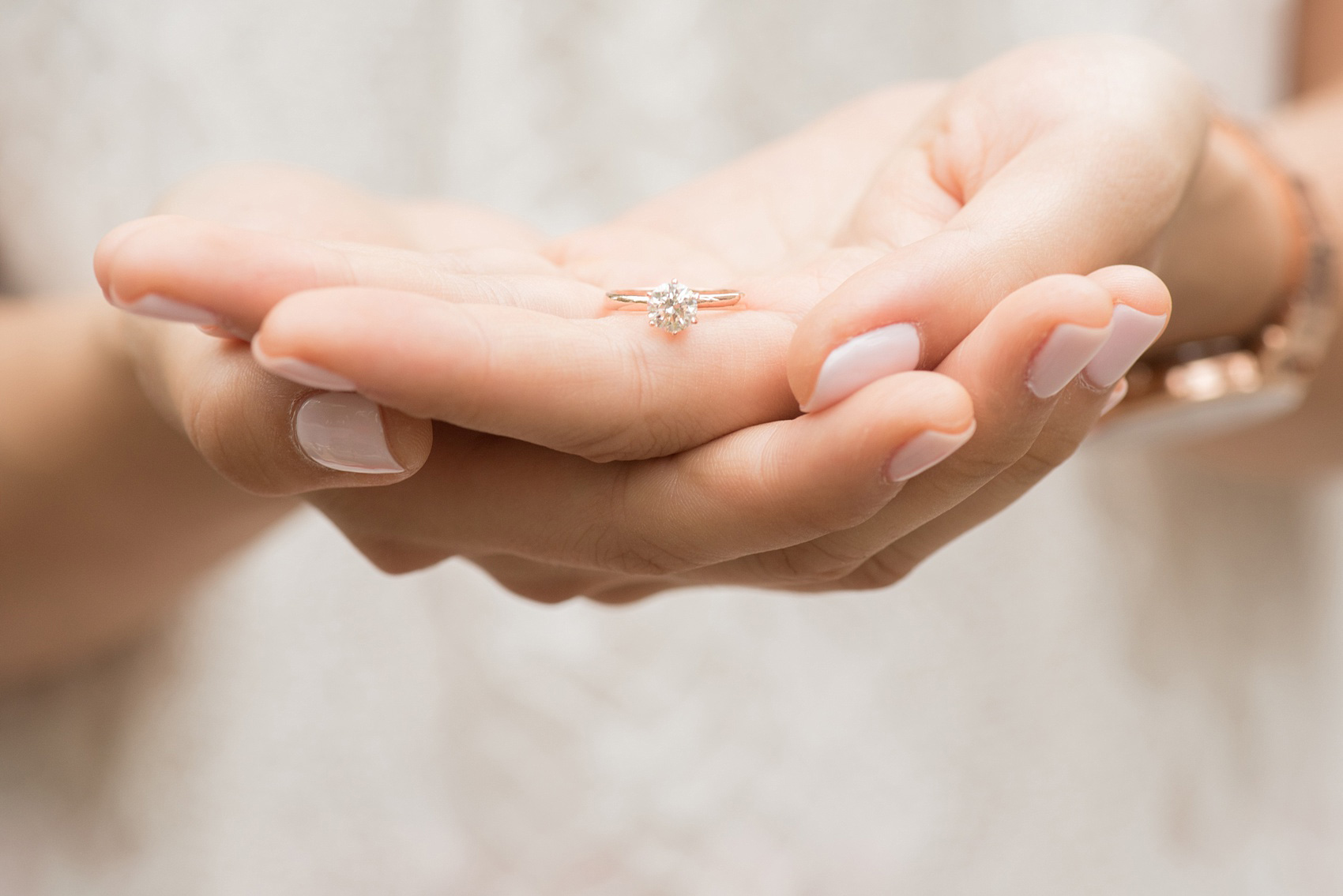 Mikkel Paige Photography photos of a Madison Square Park engagement session in NYC during spring. Detail image of the bride's solitaire white gold diamond engagement ring.
